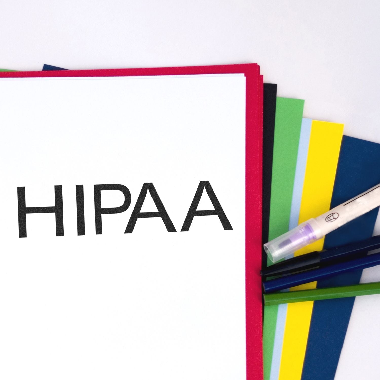 Large Self Inking HIPAA Stamp in use on a stack of colorful folders and papers, with pens and a marker nearby.