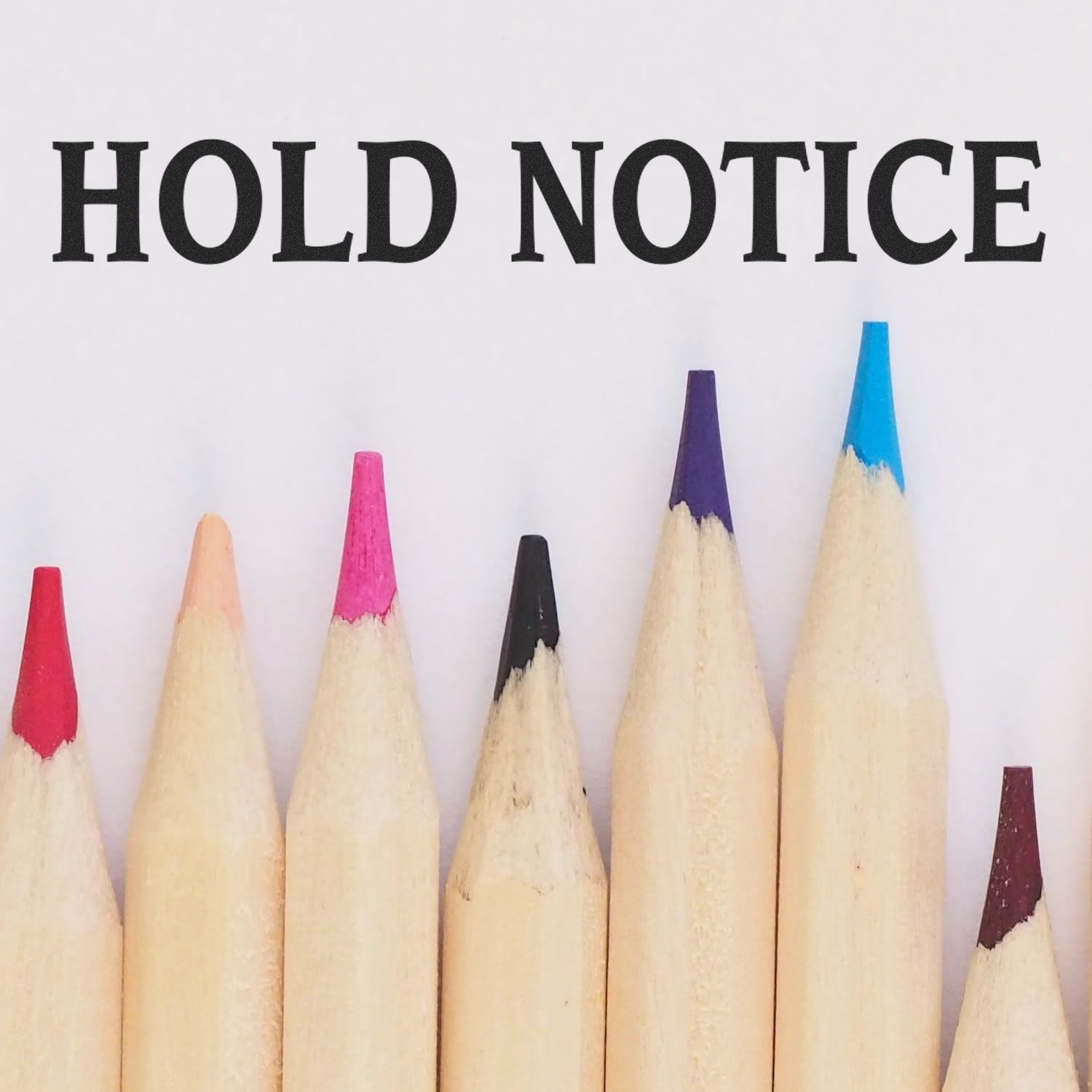 Colored pencils beneath the text HOLD NOTICE stamped using the Self Inking Hold Notice Stamp.