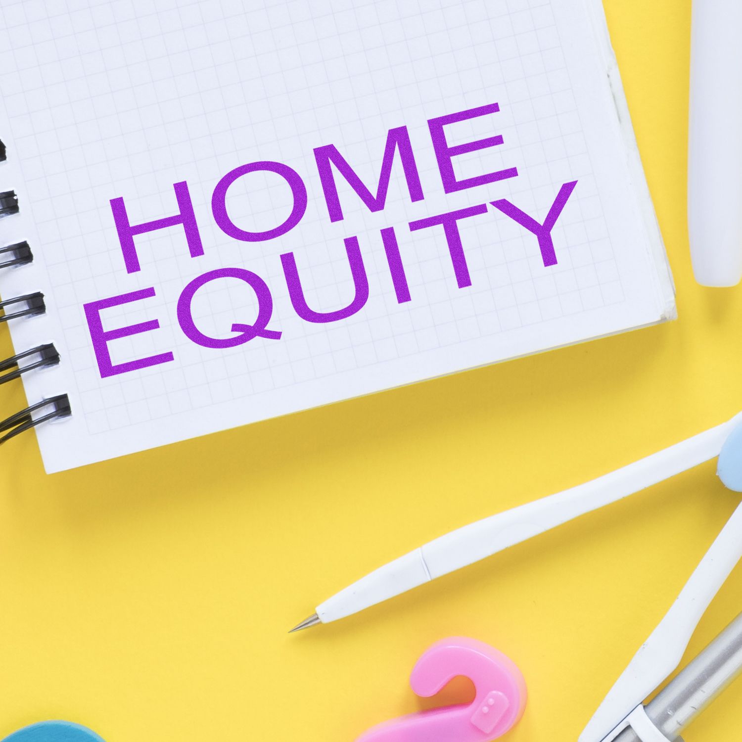 Notebook with HOME EQUITY stamped in purple using the Self Inking Home Equity Stamp, surrounded by office supplies on a yellow background.