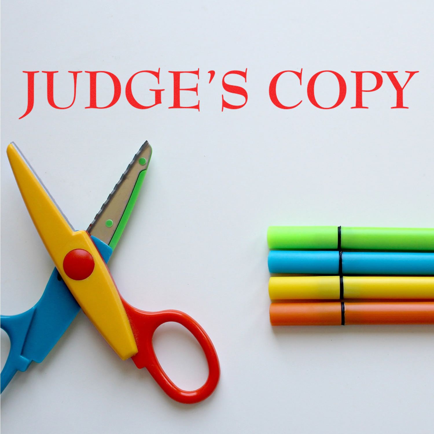 Colorful scissors and markers next to a red JUDGE'S COPY imprint made with the Judges Copy Legal Rubber Stamp on a white surface.