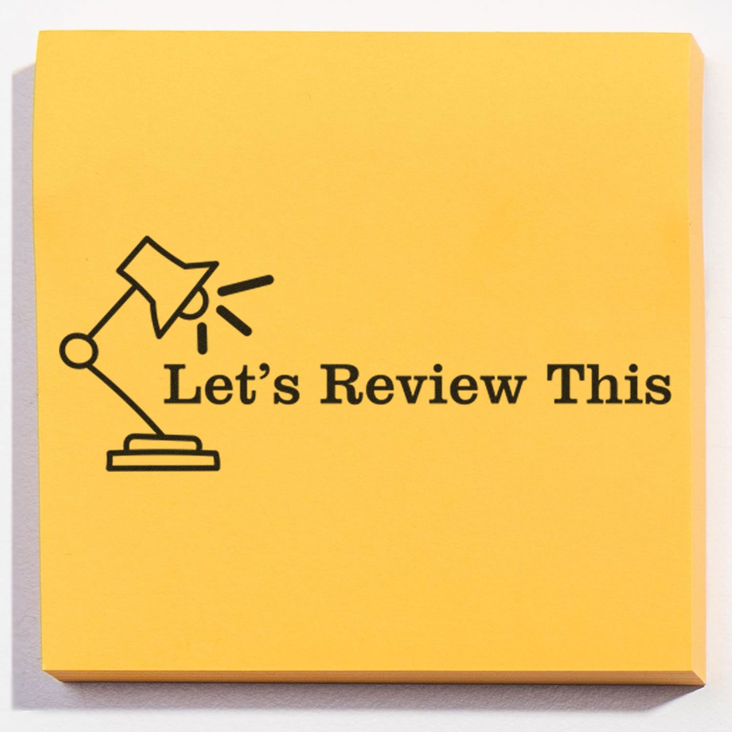 Yellow sticky note with "Let's Review This" and a lamp graphic stamped on it using the "Let's Review This with Lamp Rubber Stamp".