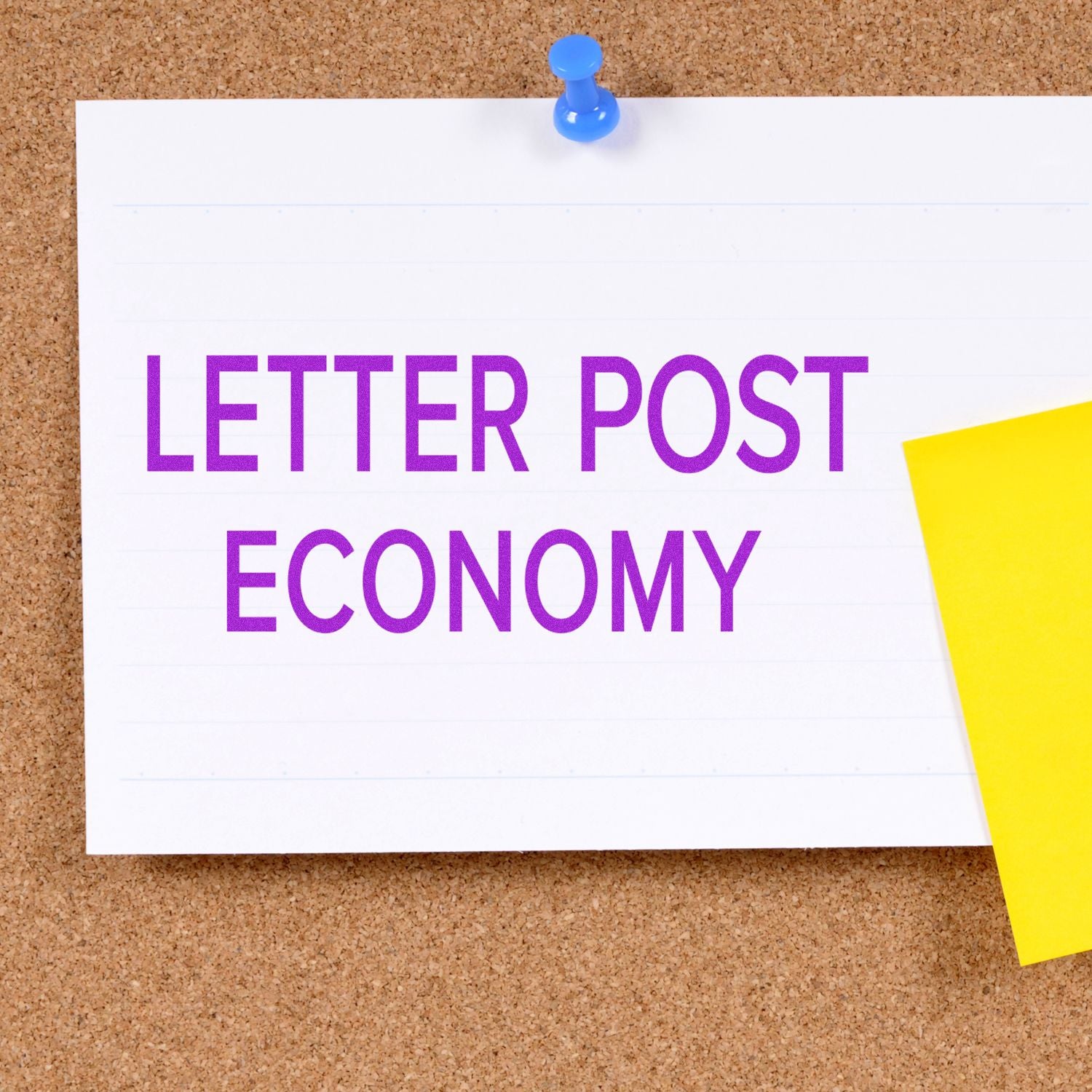 A corkboard with a white paper pinned, displaying the words LETTER POST ECONOMY in purple, next to a yellow sticky note.