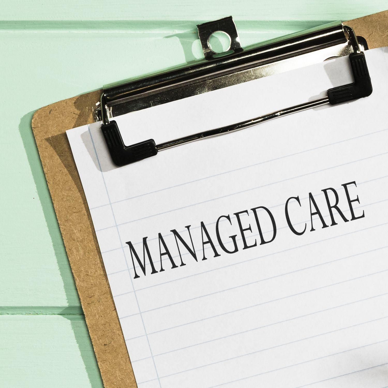 Clipboard with a paper stamped 'Managed Care' in bold letters, representing a Managed Care Rubber Stamp in use.