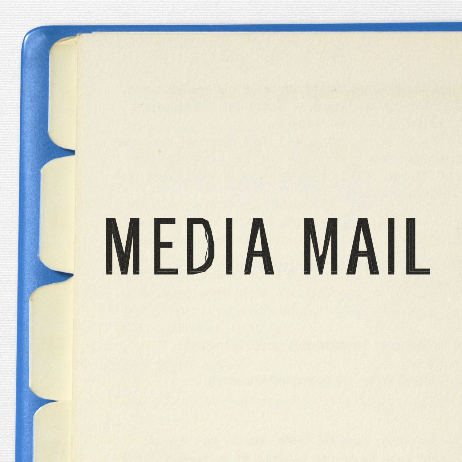 Large Self Inking Media Mail Stamp used on a document, showing clear and bold 'MEDIA MAIL' text on a white page with blue tabs.