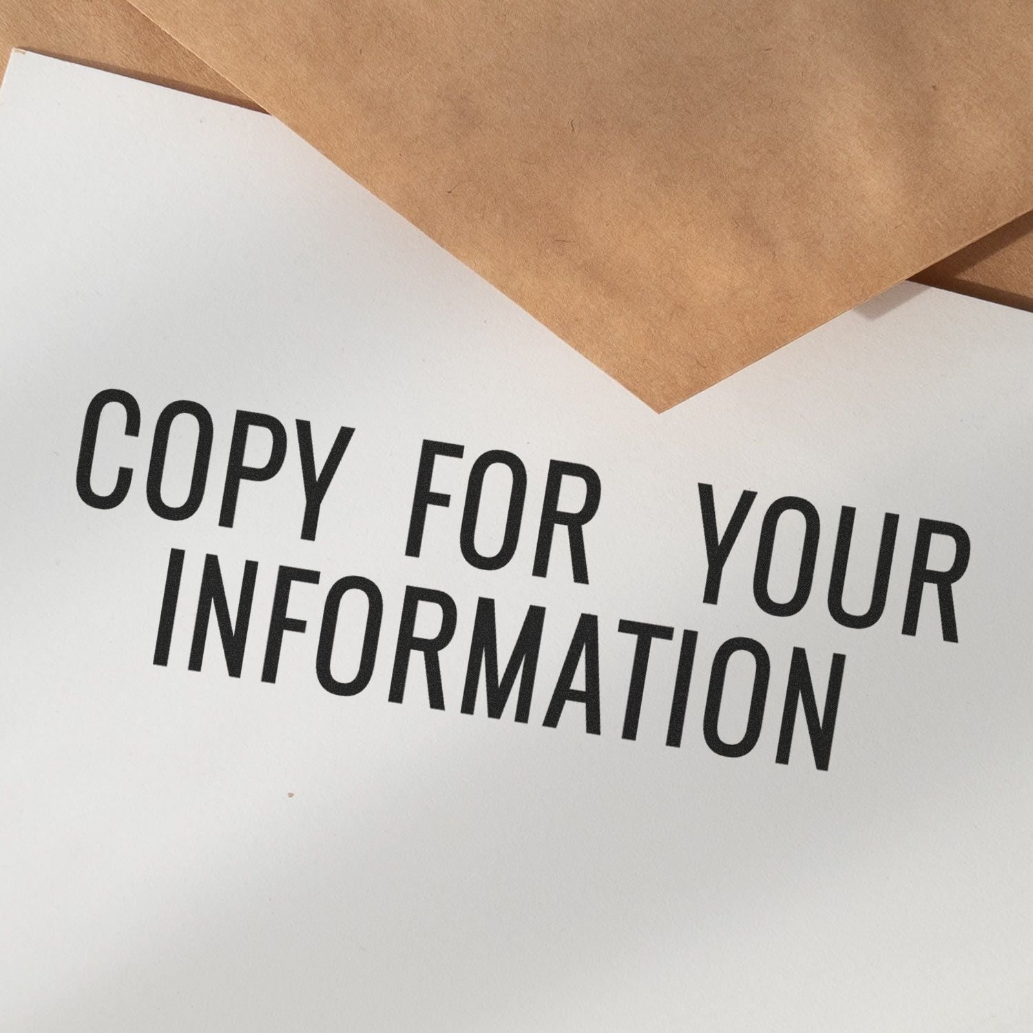 Narrow Copy for your Information Rubber Stamp used on white paper with brown envelopes in the background.