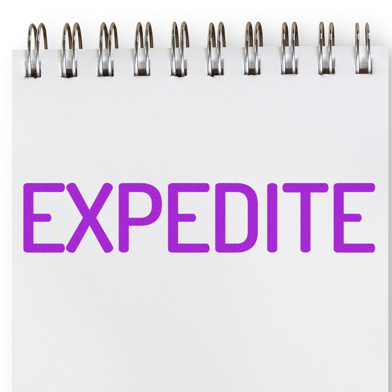 Large Narrow Expedite Rubber Stamp in use, stamping the word EXPEDITE in purple ink on a white notepad with a spiral binding.