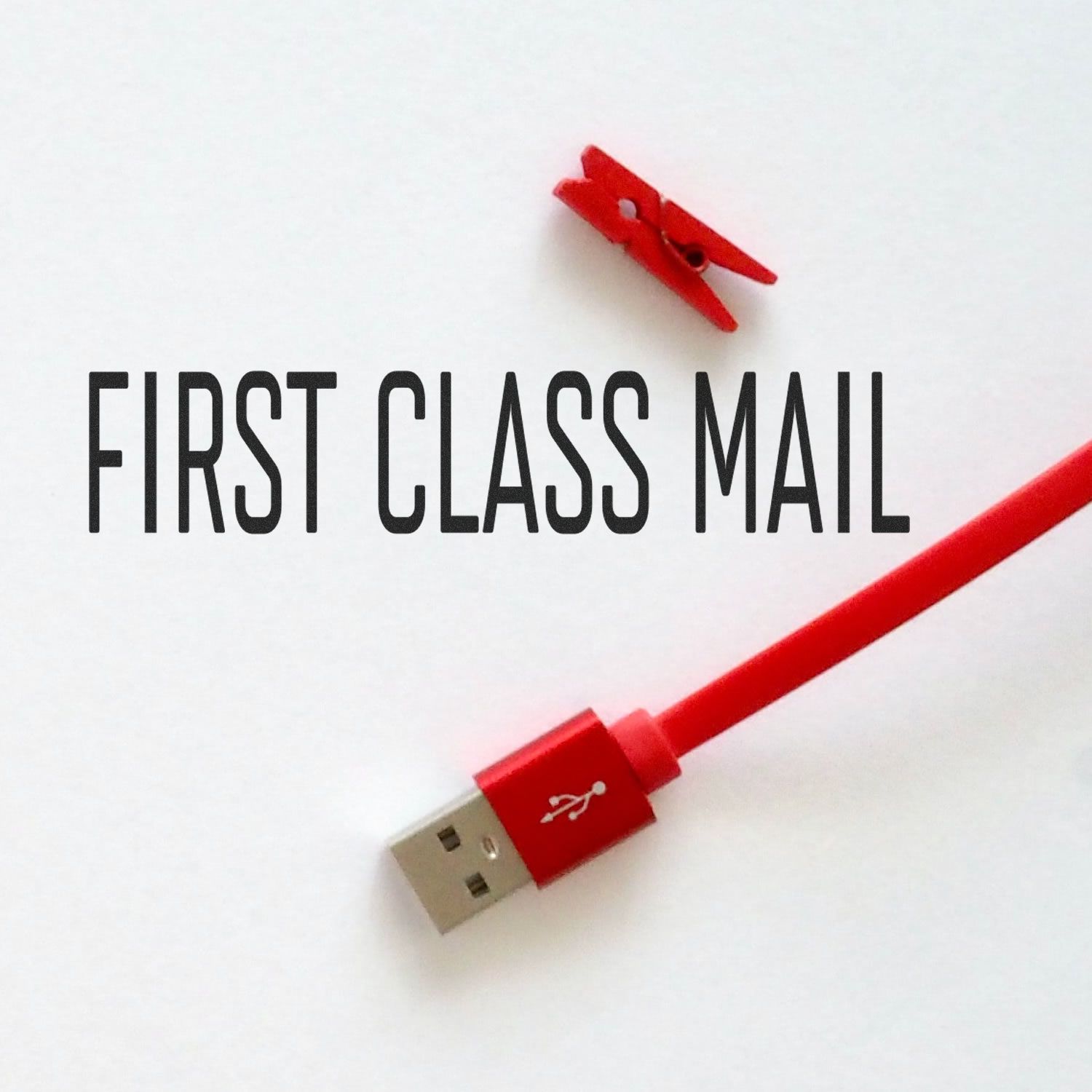 Narrow Font First Class Mail rubber stamp with a red USB cable and a small red clothespin on a white background.