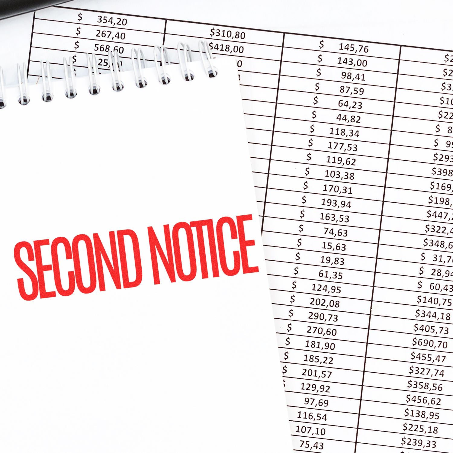 Narrow Font Second Notice Rubber Stamp in red ink on a notepad, placed over a financial spreadsheet with various amounts.