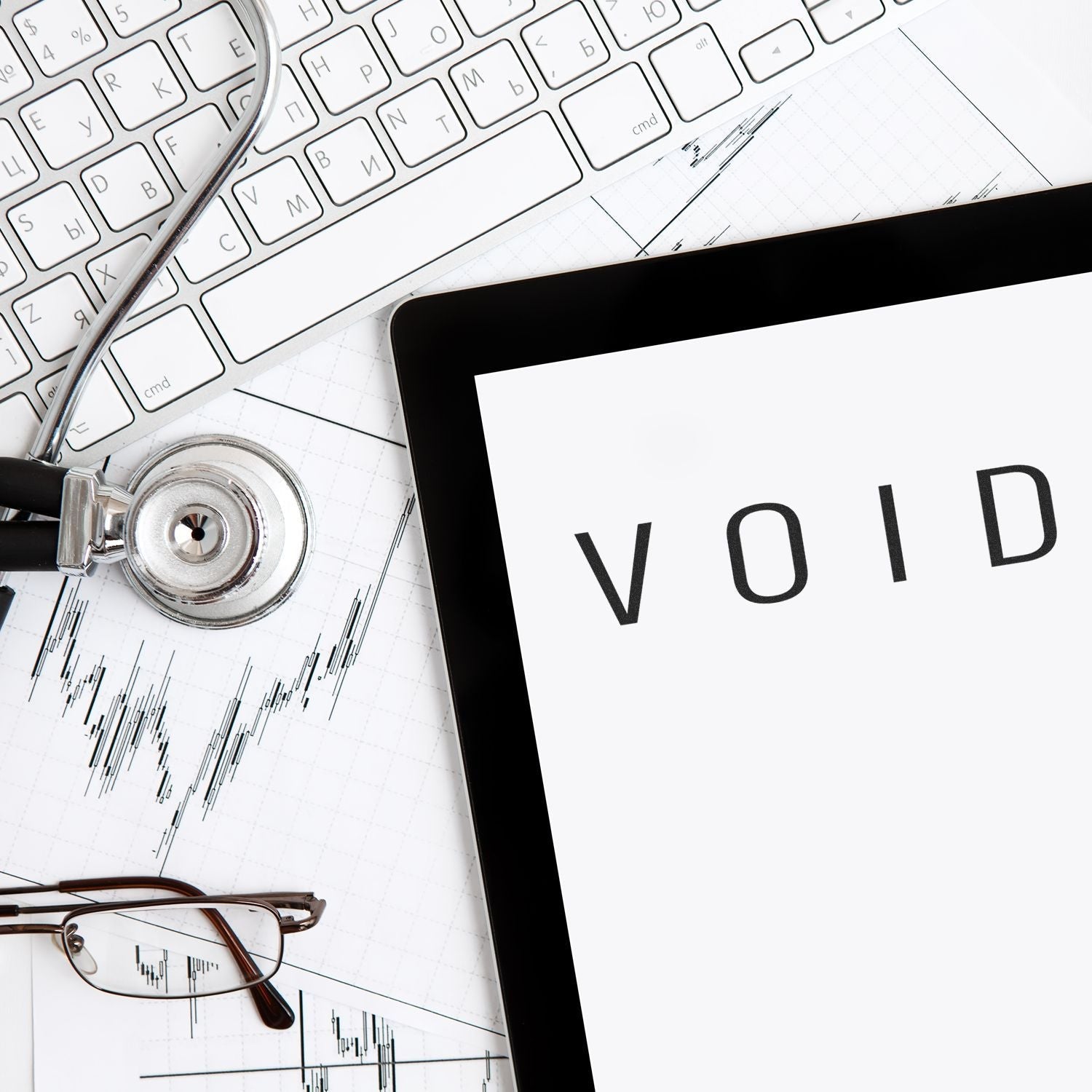 Self Inking Narrow Void Stamp marking VOID on a document, with a keyboard, stethoscope, glasses, and tablet in the background.