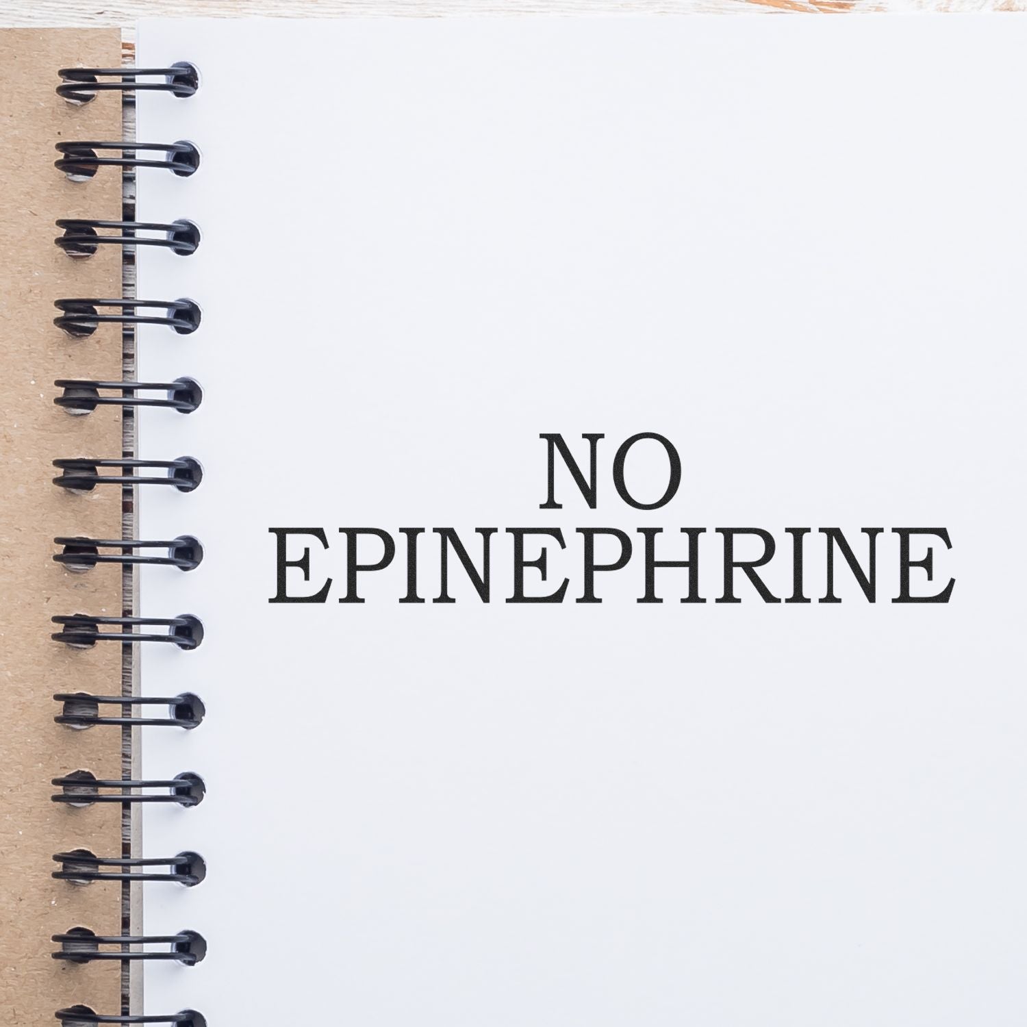 Slim Pre-Inked No Epinephrine Stamp used on a white notebook page with spiral binding, displaying NO EPINEPHRINE in bold text.