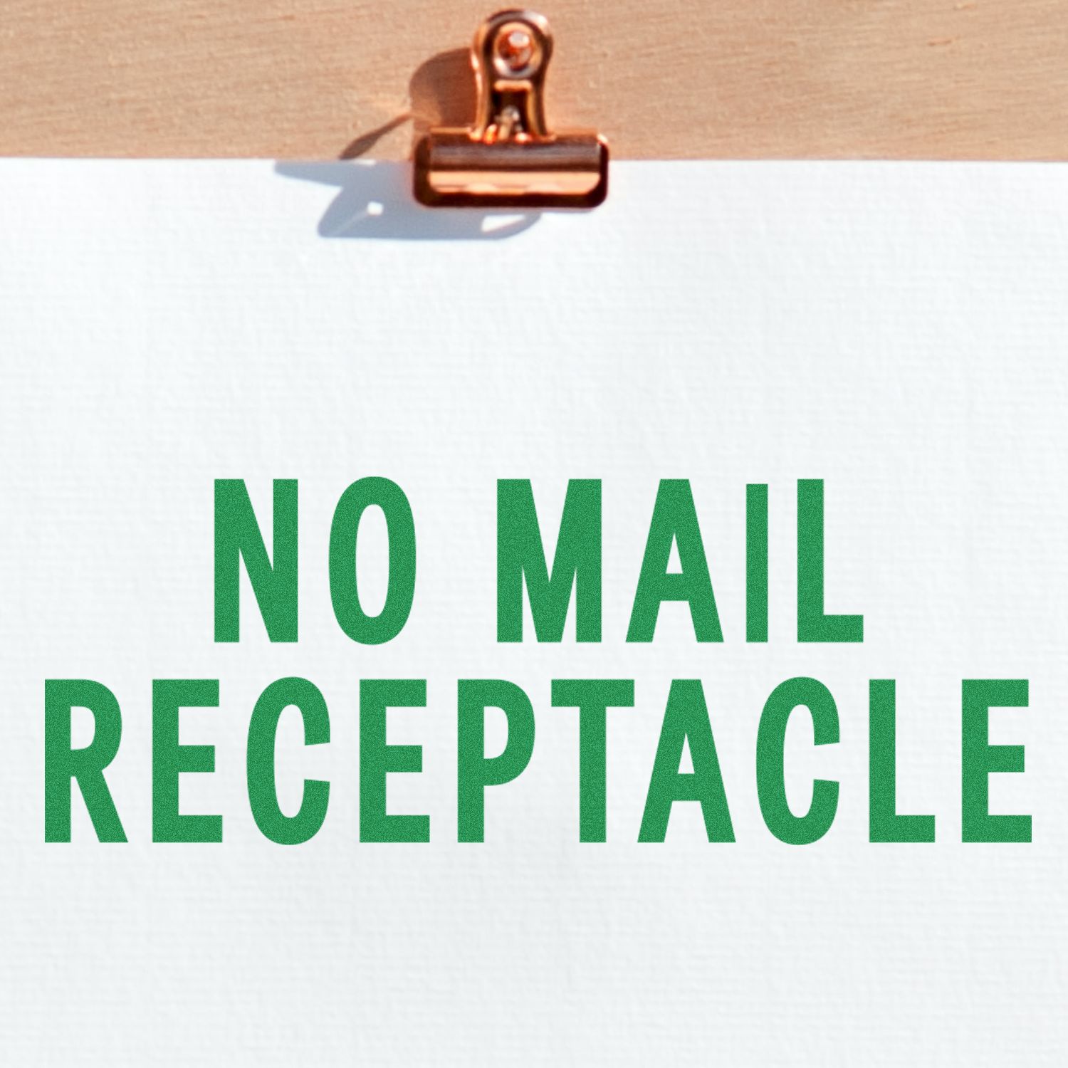 Large No Mail Receptacle Rubber Stamp in use, displaying a clear green NO MAIL RECEPTACLE message on white paper clipped to a wooden board.