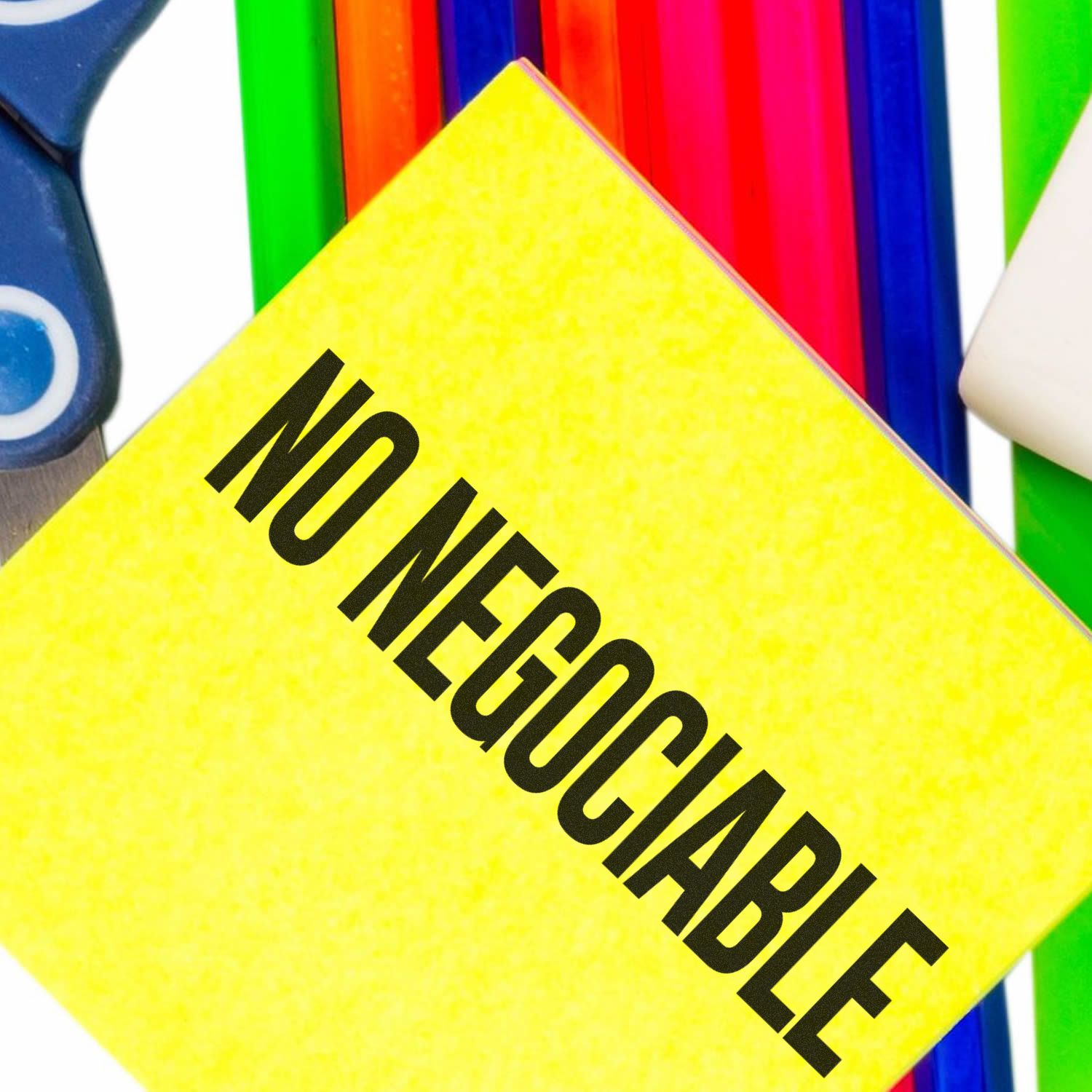 Self Inking No Negociable Stamp imprint on a bright yellow paper, surrounded by colorful office supplies in the background.