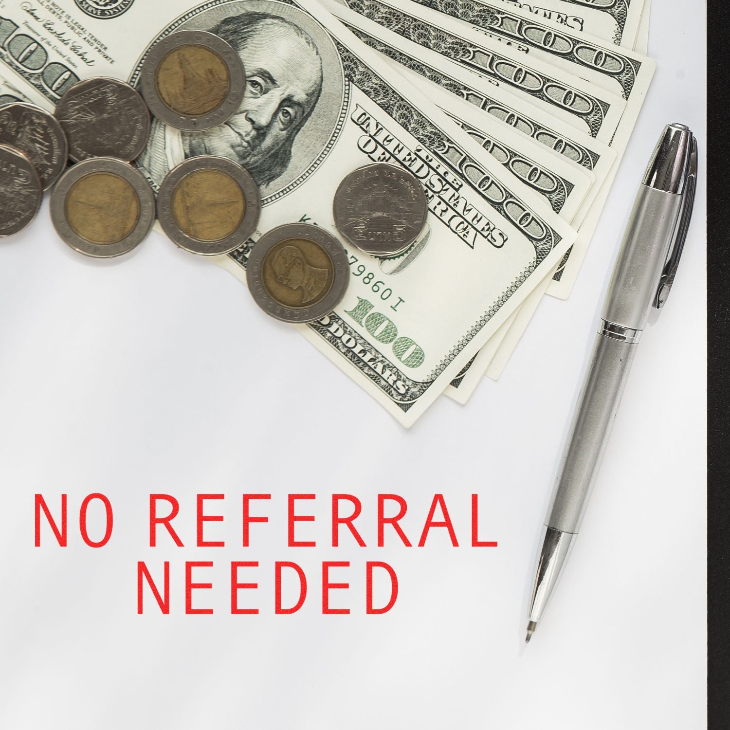 Slim Pre-Inked No Referral Needed Stamp next to a pen, coins, and dollar bills on a white surface with No Referral Needed text.