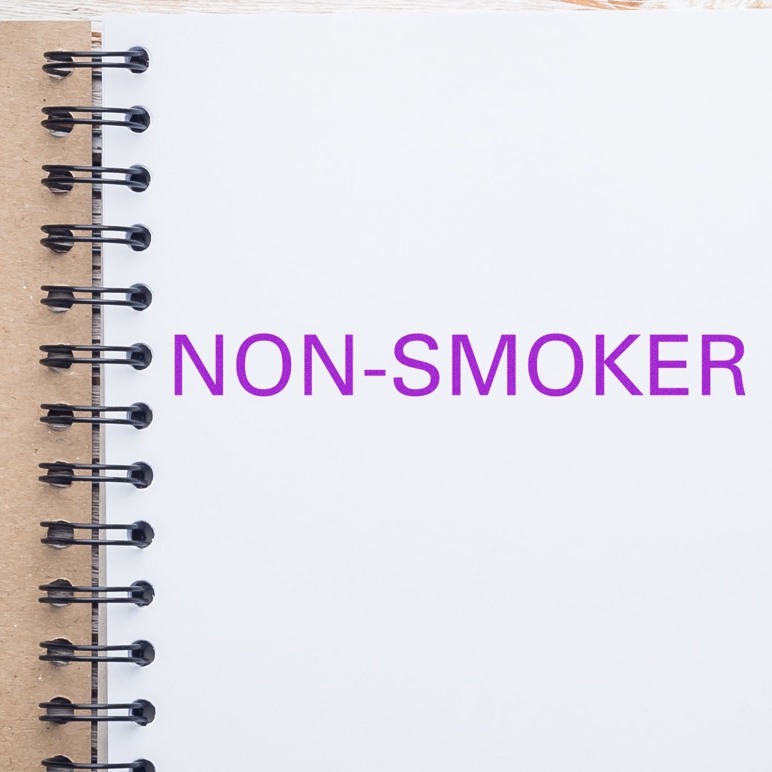 Self Inking Non-Smoker Stamp used on a white notebook page, displaying the text NON-SMOKER in purple ink.