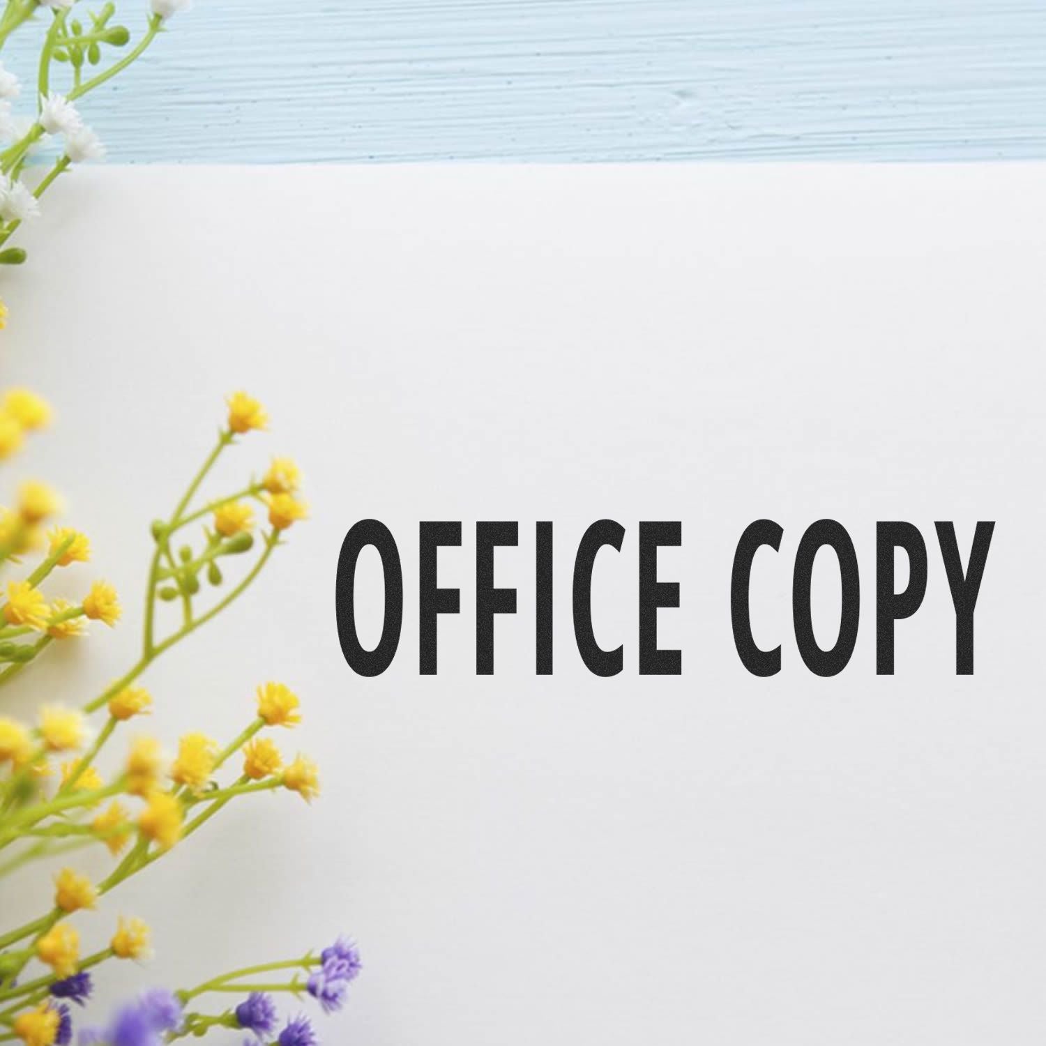 Office Copy Rubber Stamp imprint on white paper with yellow and purple flowers on the left side.