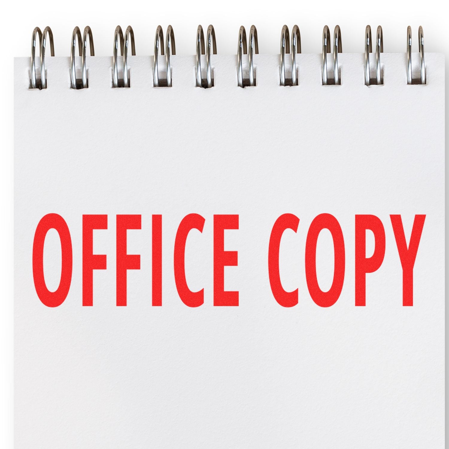 Large Office Copy Rubber Stamp imprinting "OFFICE COPY" in bold red letters on a white notepad with a spiral binding.