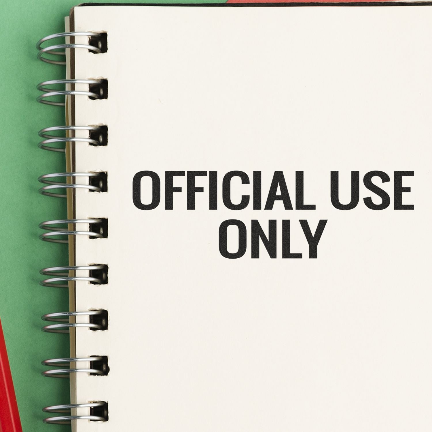 A notebook stamped with OFFICIAL USE ONLY using the Large Official Use Only Rubber Stamp, placed on a green and red background.