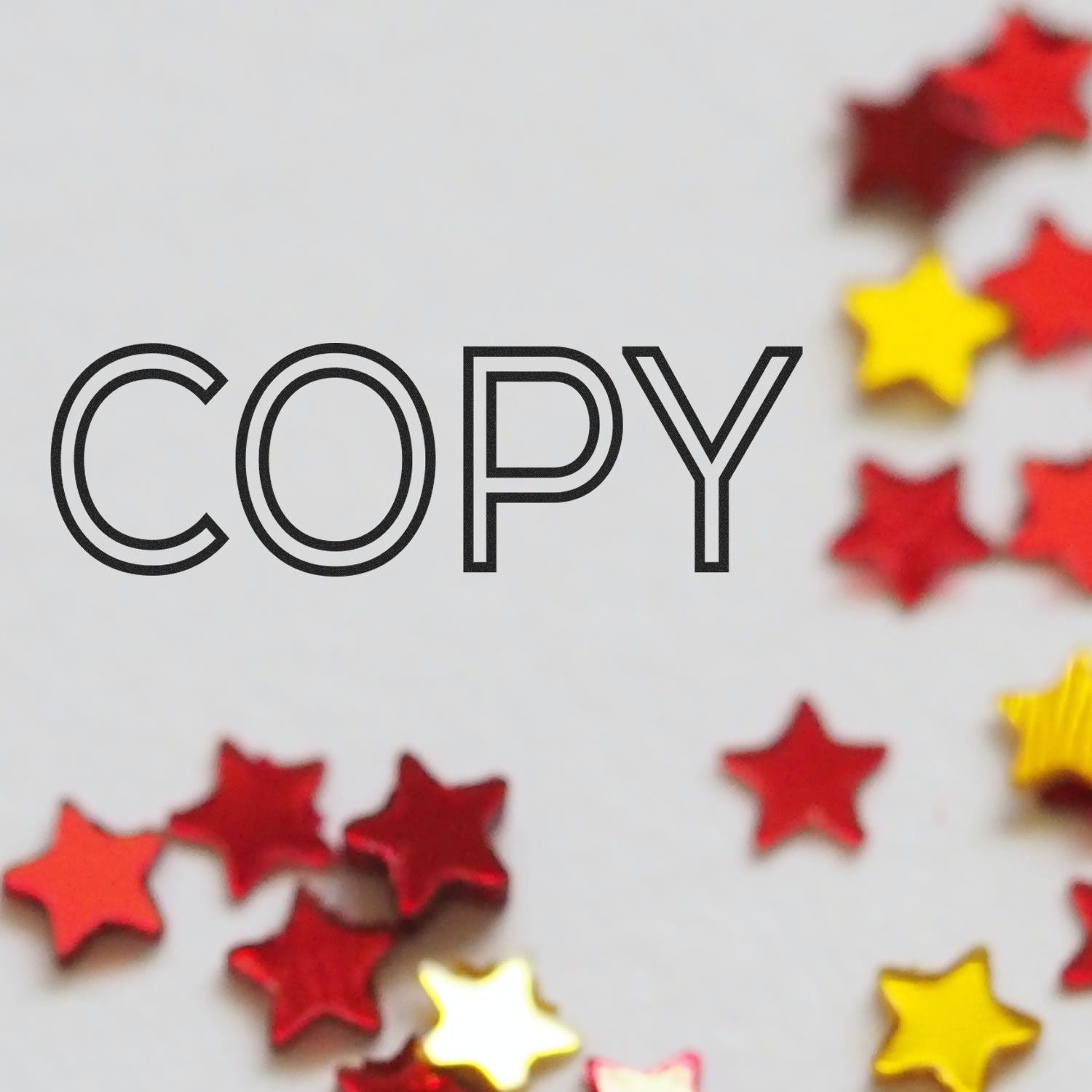 Outline Copy Rubber Stamp with the word 'COPY' in bold black letters, surrounded by scattered red and yellow star confetti.