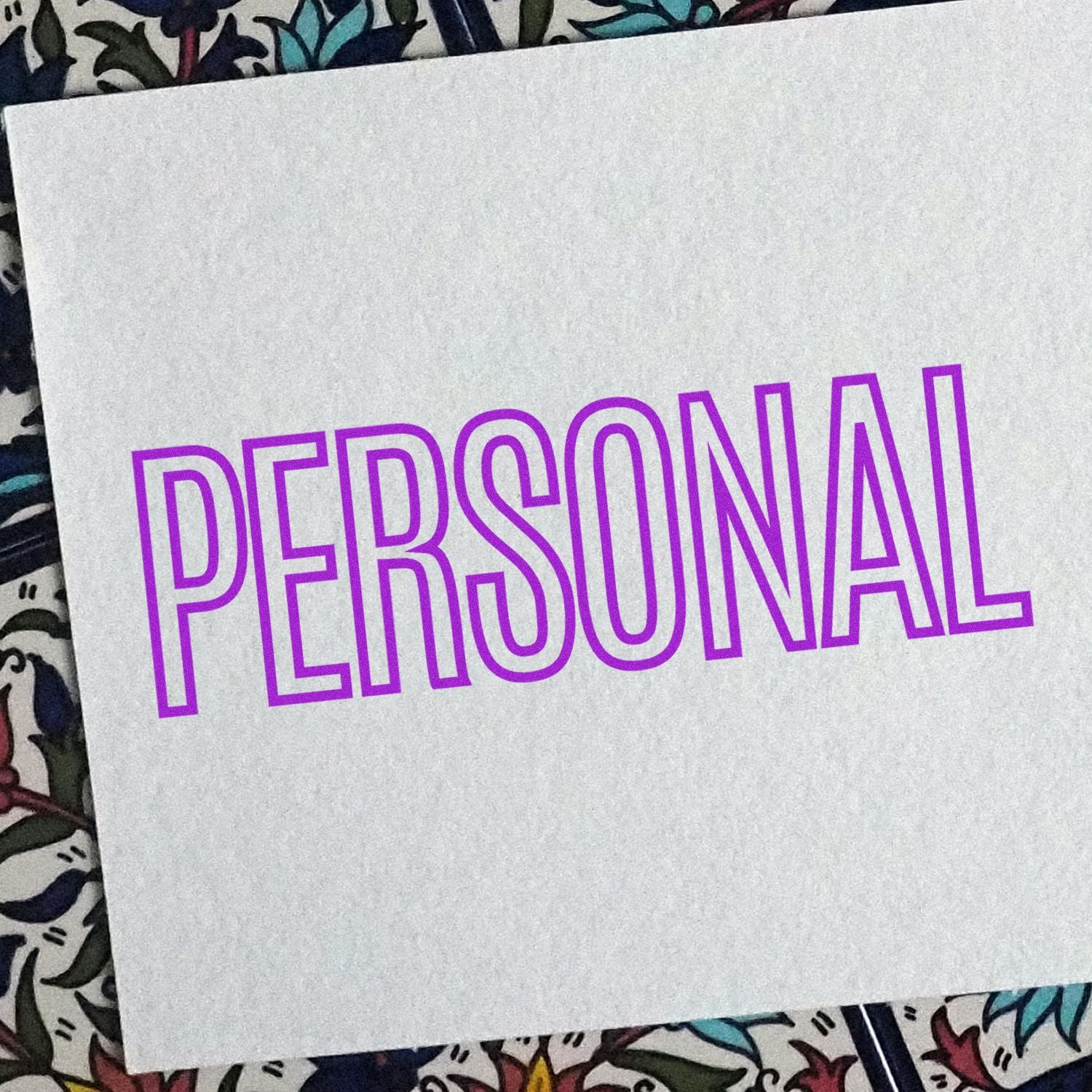 Outline Personal Rubber Stamp in purple ink on white paper with a colorful patterned background.