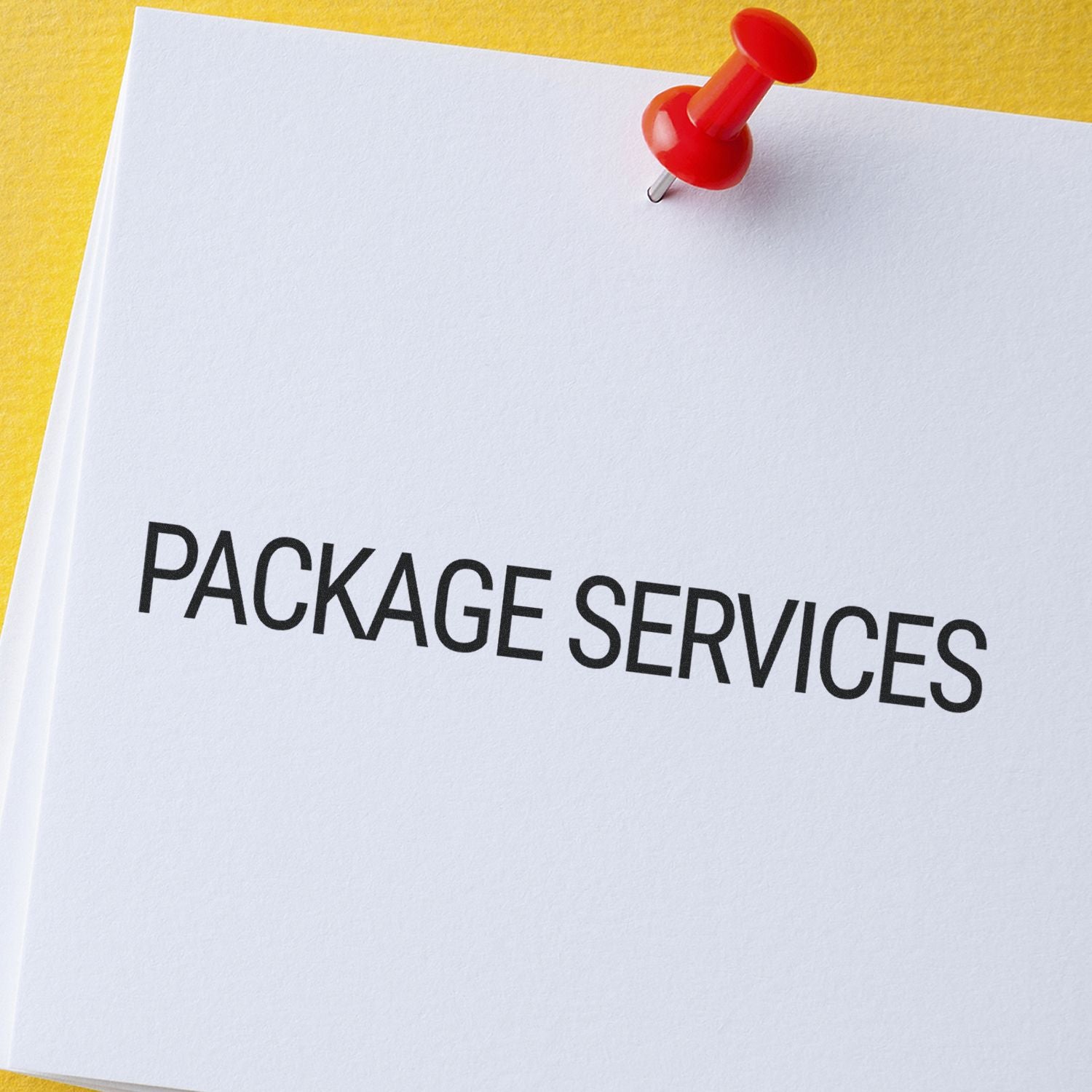 Large Pre-Inked Package Services Stamp marking PACKAGE SERVICES on white paper with a red pushpin on a yellow background.