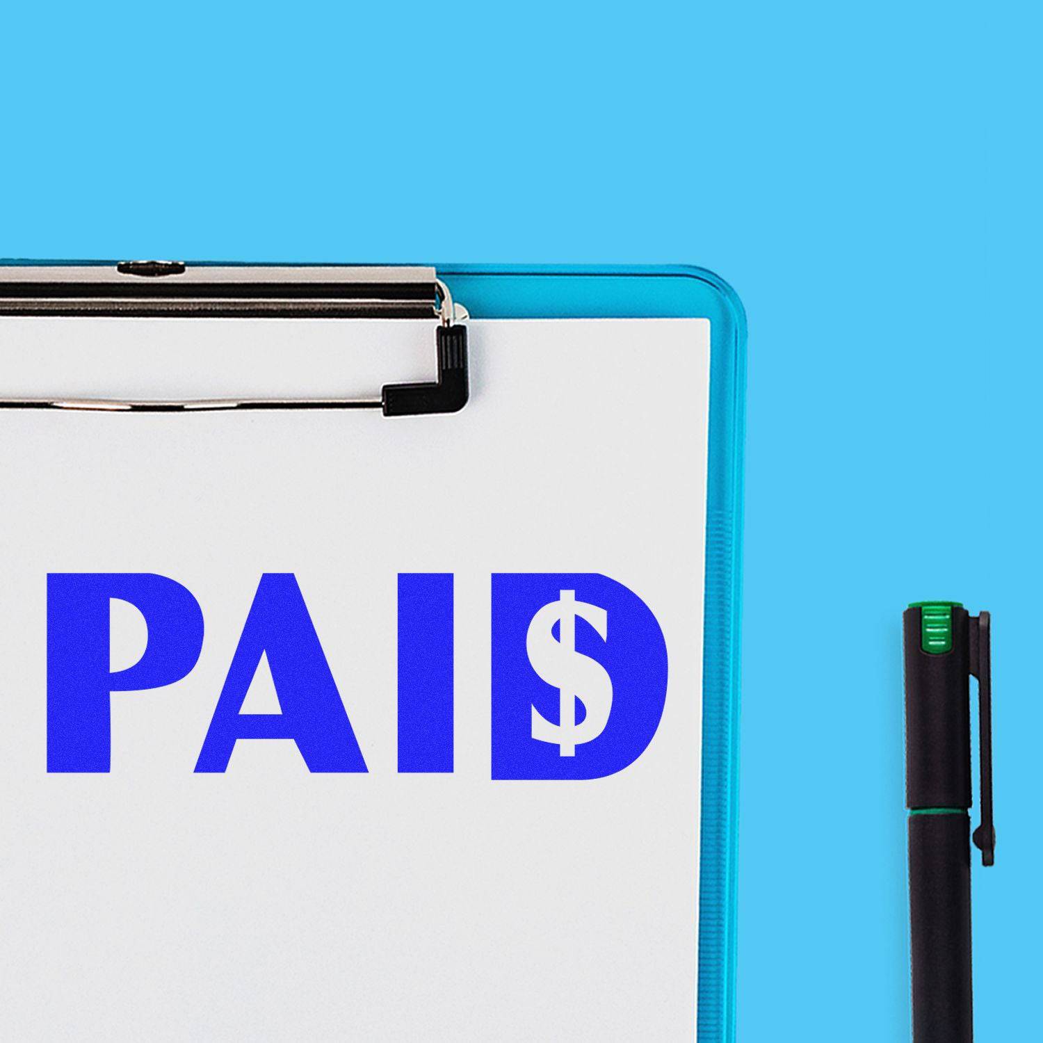 A clipboard with a paper stamped PAID using the Large Paid with Dollar Sign Rubber Stamp, next to a black pen on a blue background.