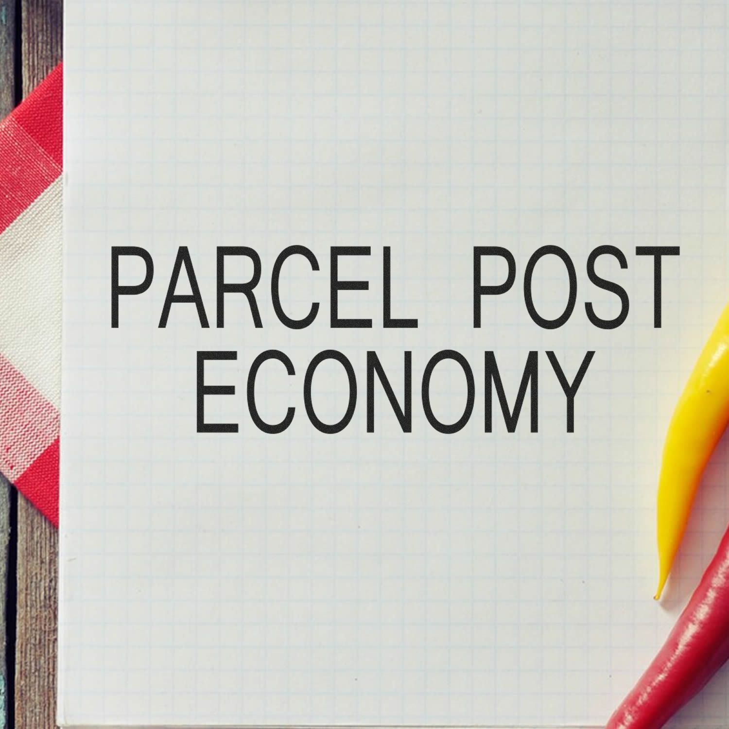 Parcel Post Economy rubber stamp on a white grid paper with a red and white cloth and yellow chili pepper on the side.