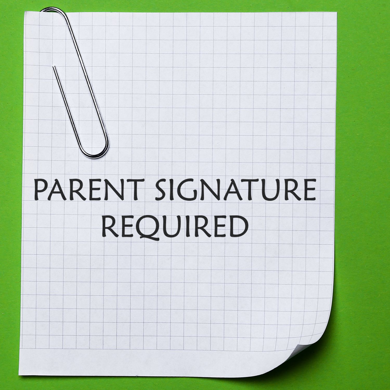 A paper with a Parent Signature Required rubber stamp, clipped with a paperclip, on a green background.