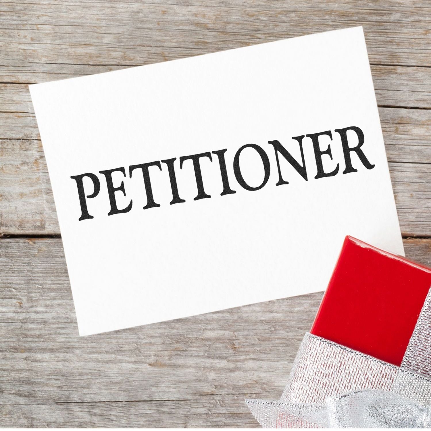 A Large Petitioner Rubber Stamp with a red handle is shown stamping the word PETITIONER in bold black letters on a white card.