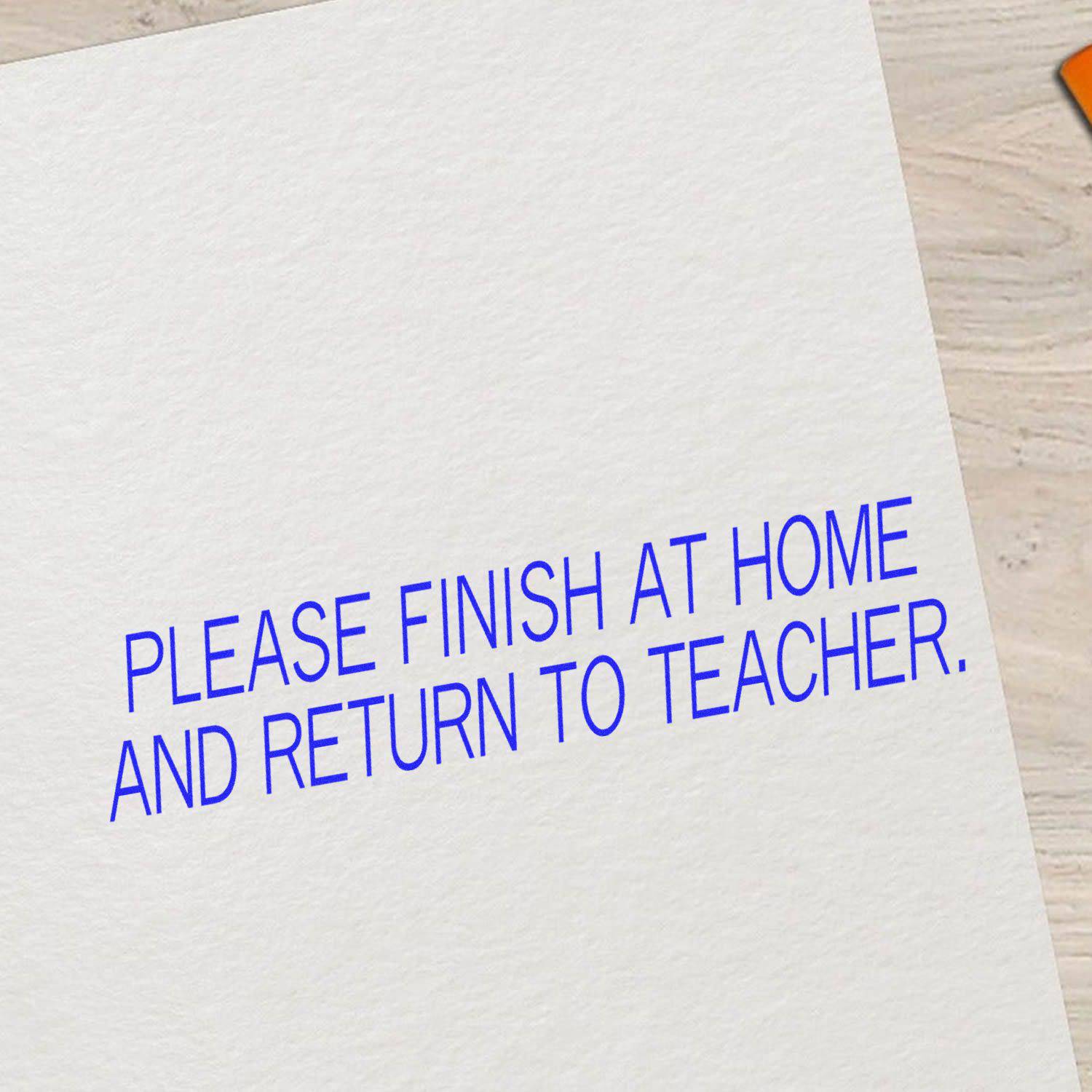 A paper stamped with PLEASE FINISH AT HOME AND RETURN TO TEACHER using the Large Please Finish At Home And Return To Teacher Rubber Stamp.