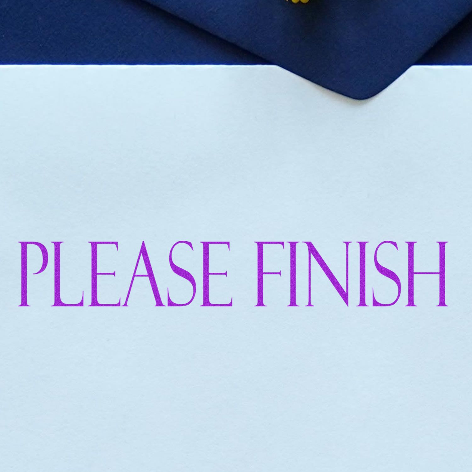 Please Finish rubber stamp in purple ink on a white paper, placed on a dark blue surface.