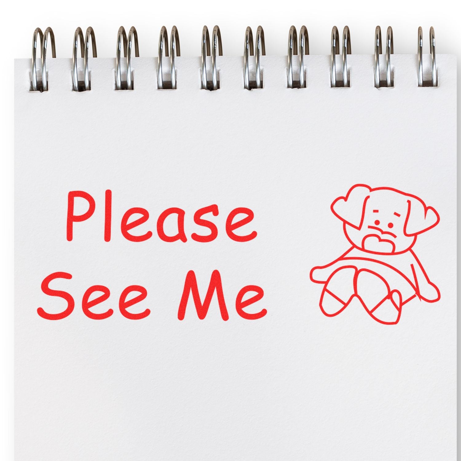 Please See Me rubber stamp impression in red on a white notepad with a spiral binding, featuring a sad cartoon dog.