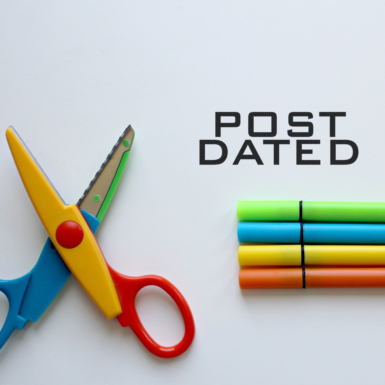 Self Inking Post Dated Stamp in use, with colorful scissors and markers on a white surface.