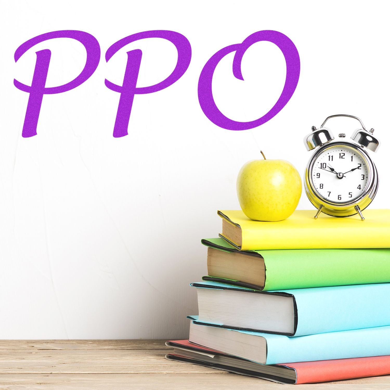 Large PPO Rubber Stamp in use, with PPO stamped in purple on a white wall. An apple, alarm clock, and colorful books are on a wooden table.