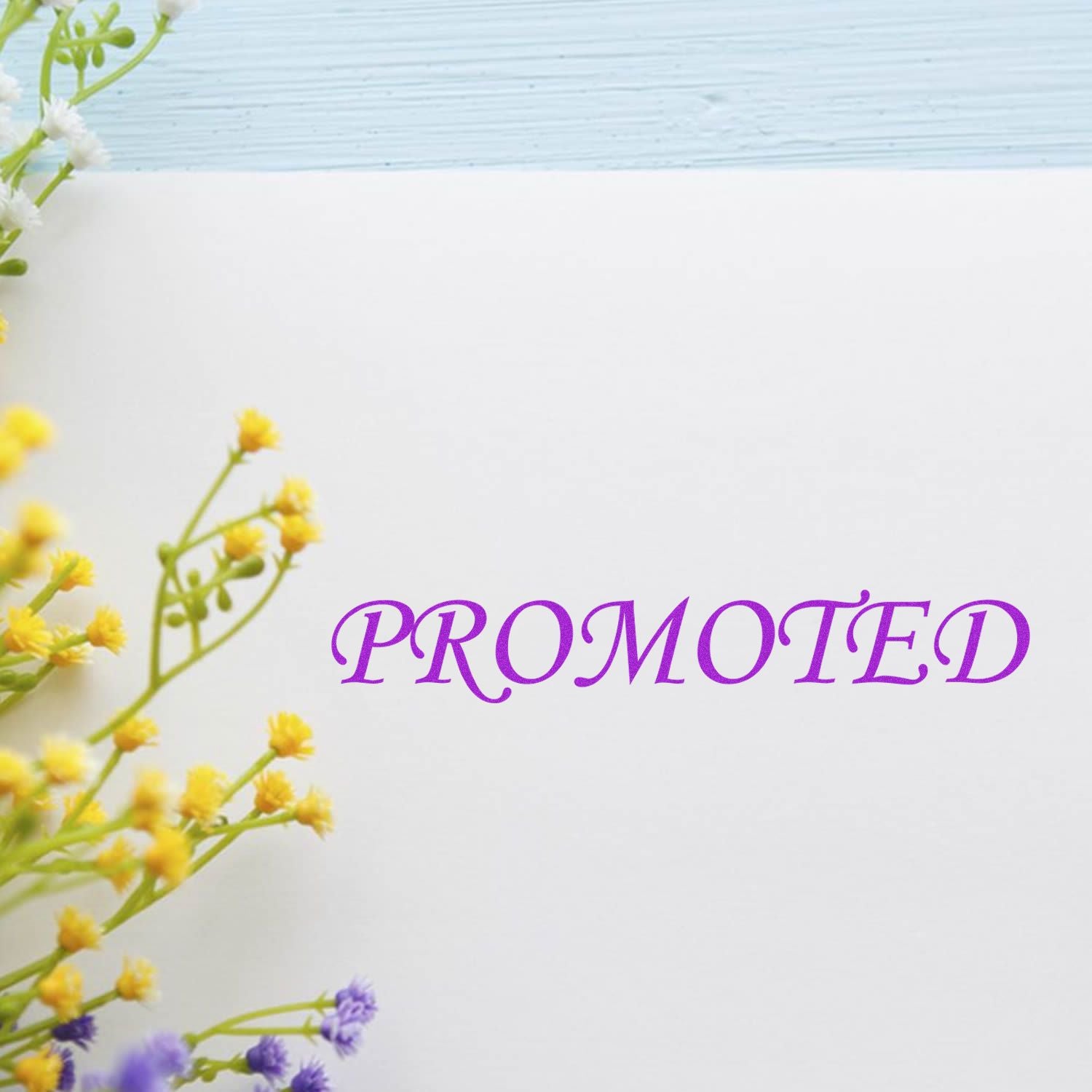 Promoted rubber stamp in purple ink on white paper with yellow and purple flowers in the corner.