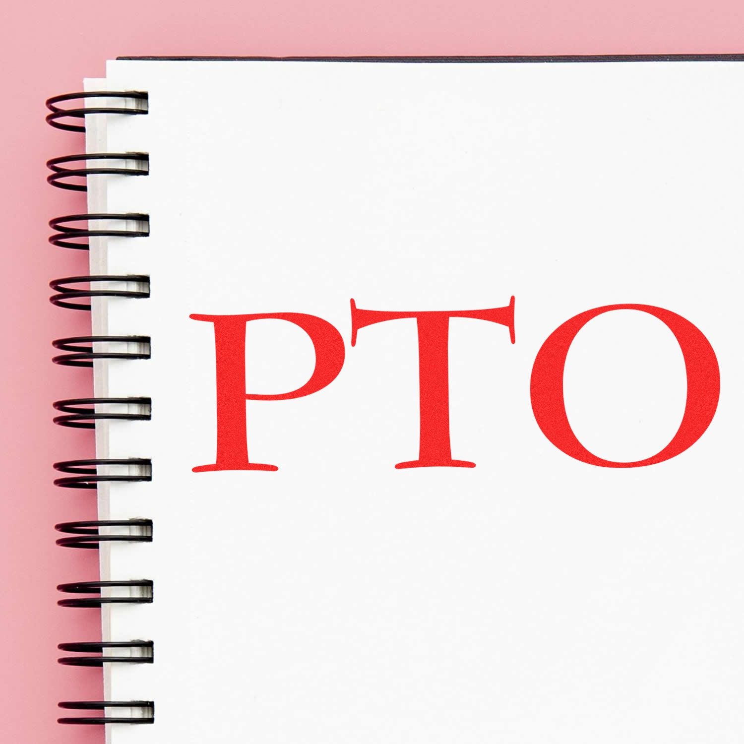 Large Pre-Inked PTO Stamp in red ink on a spiral-bound notebook with a pink background.