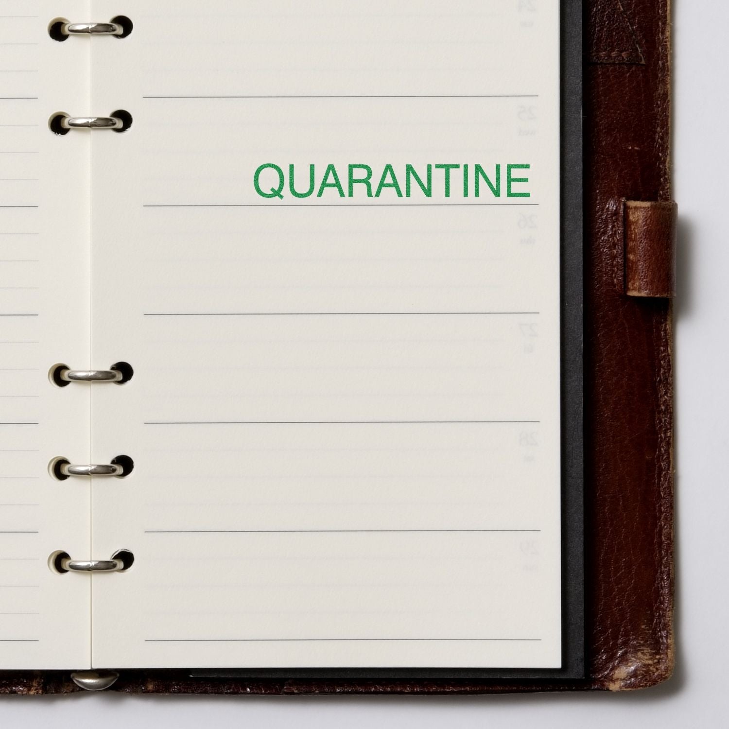 Self Inking Quarantine Stamp used on a lined notebook page, displaying the word QUARANTINE in green ink.