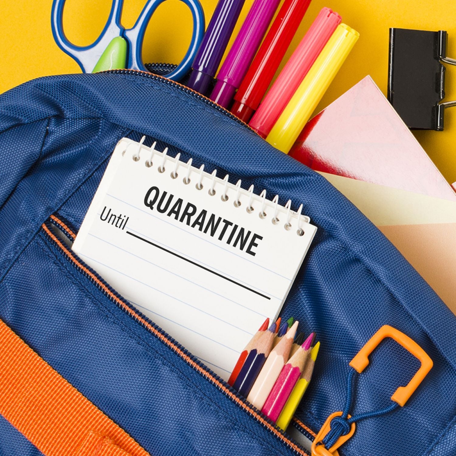 Large Quarantine Until Rubber Stamp on a notepad in a blue backpack pocket with colorful pens, pencils, scissors, and paper clips.