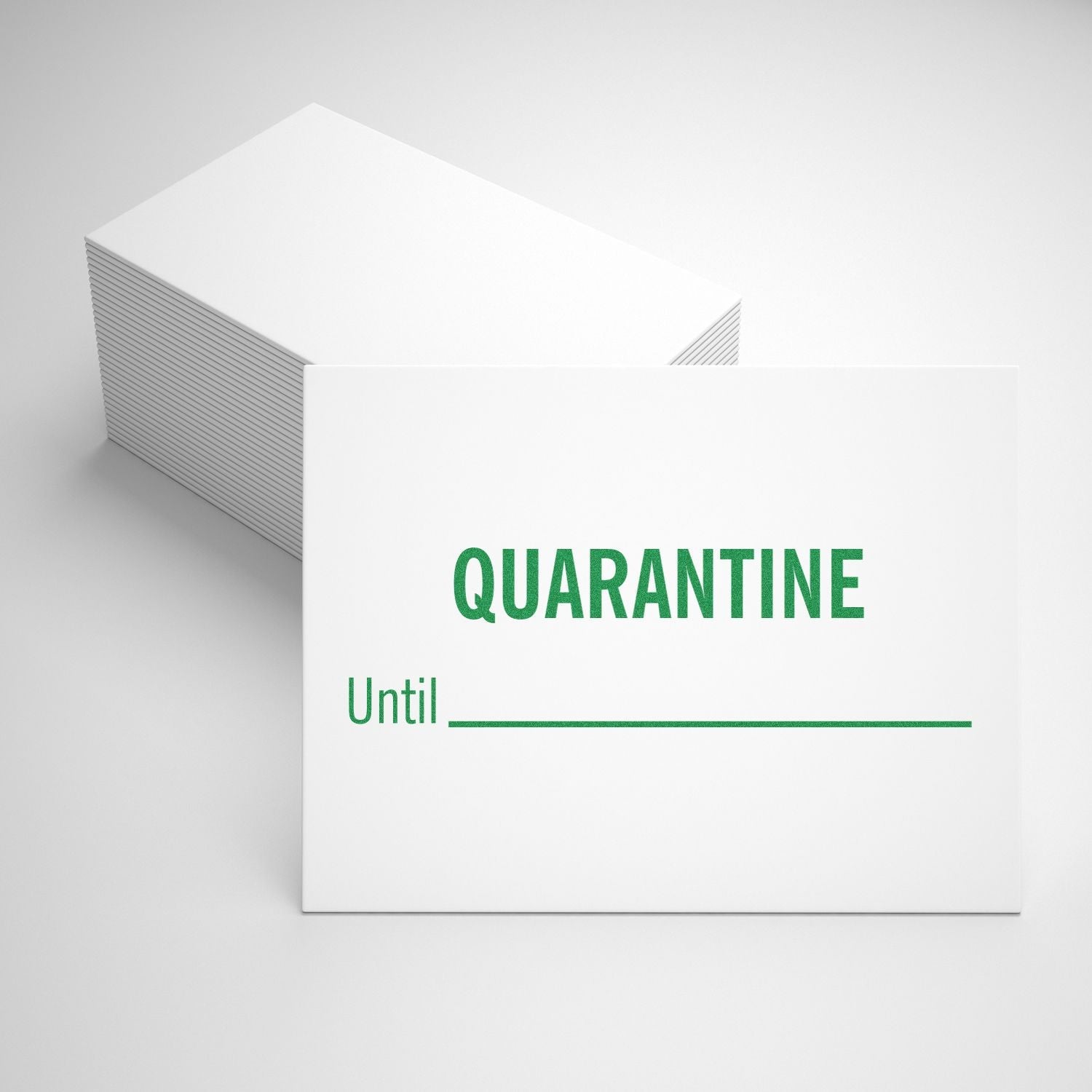 A stack of white cards stamped with QUARANTINE Until ______ using the Self Inking Quarantine Until Stamp, displayed on a white surface.