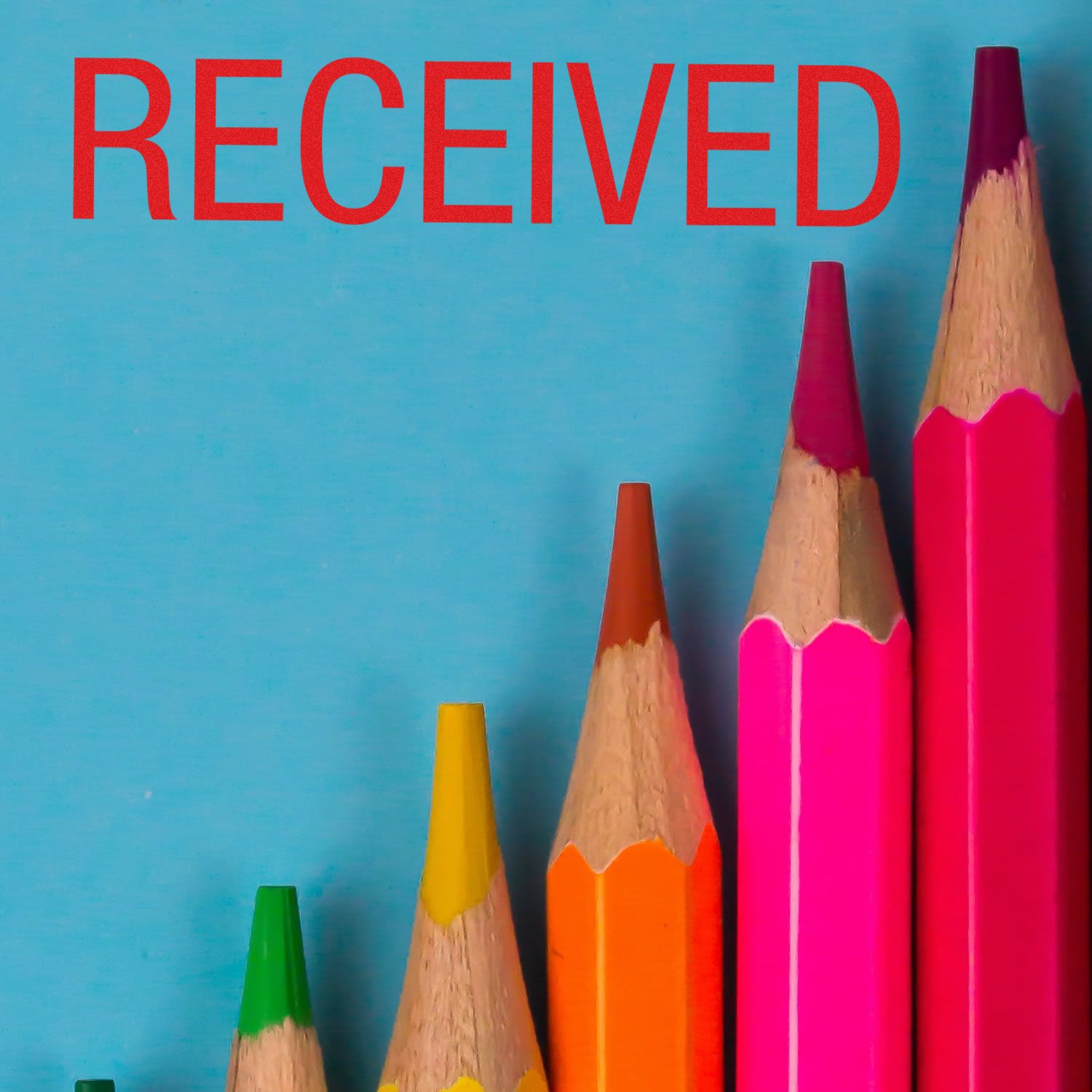 Colorful pencils arranged in ascending order with the Large Self Inking Received Stamp marking RECEIVED in red ink above them.