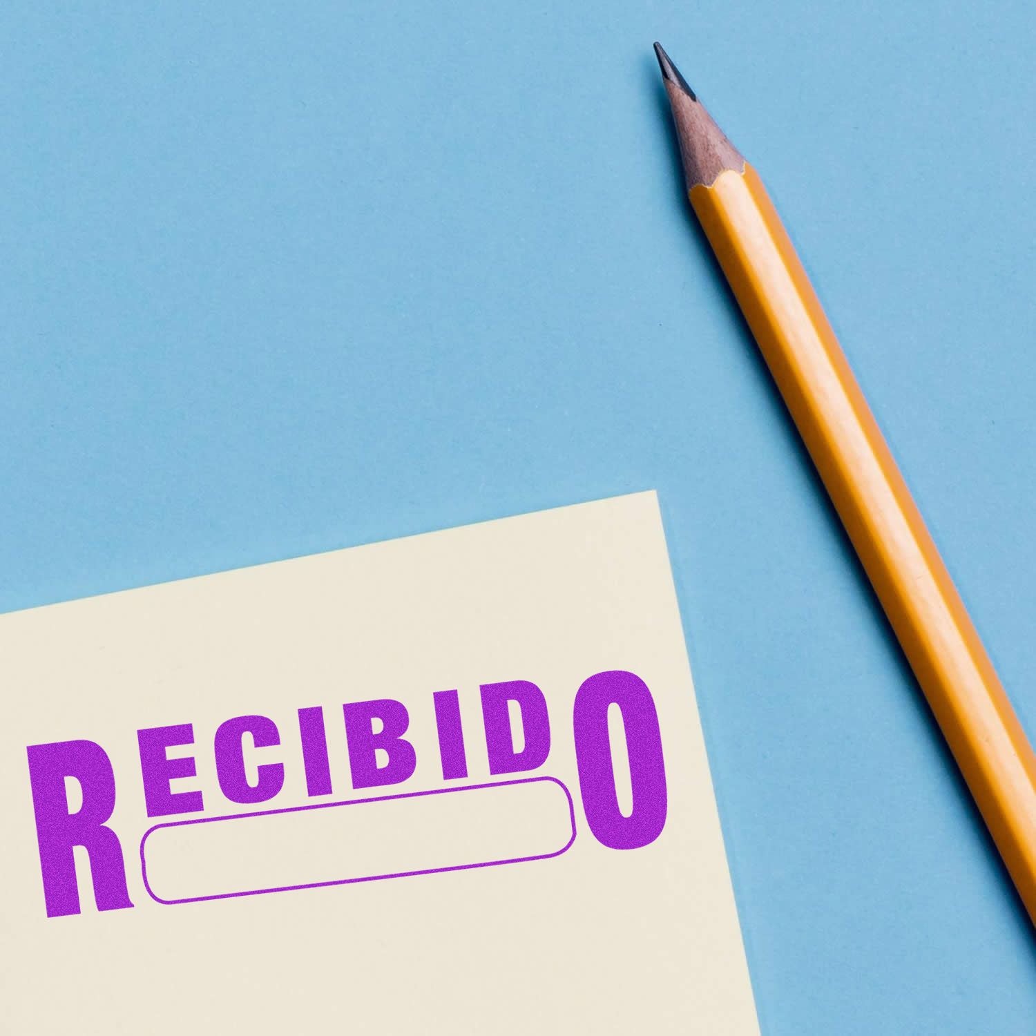 A yellow pencil next to a paper stamped with a purple Recibido rubber stamp on a blue background.