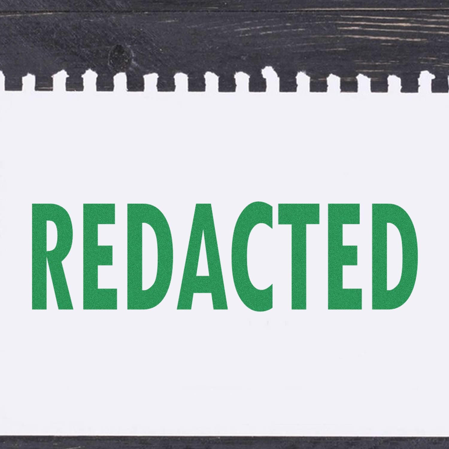 Large Redacted Rubber Stamp in use, displaying the word REDACTED in bold green letters on a white sheet of paper with a black background.