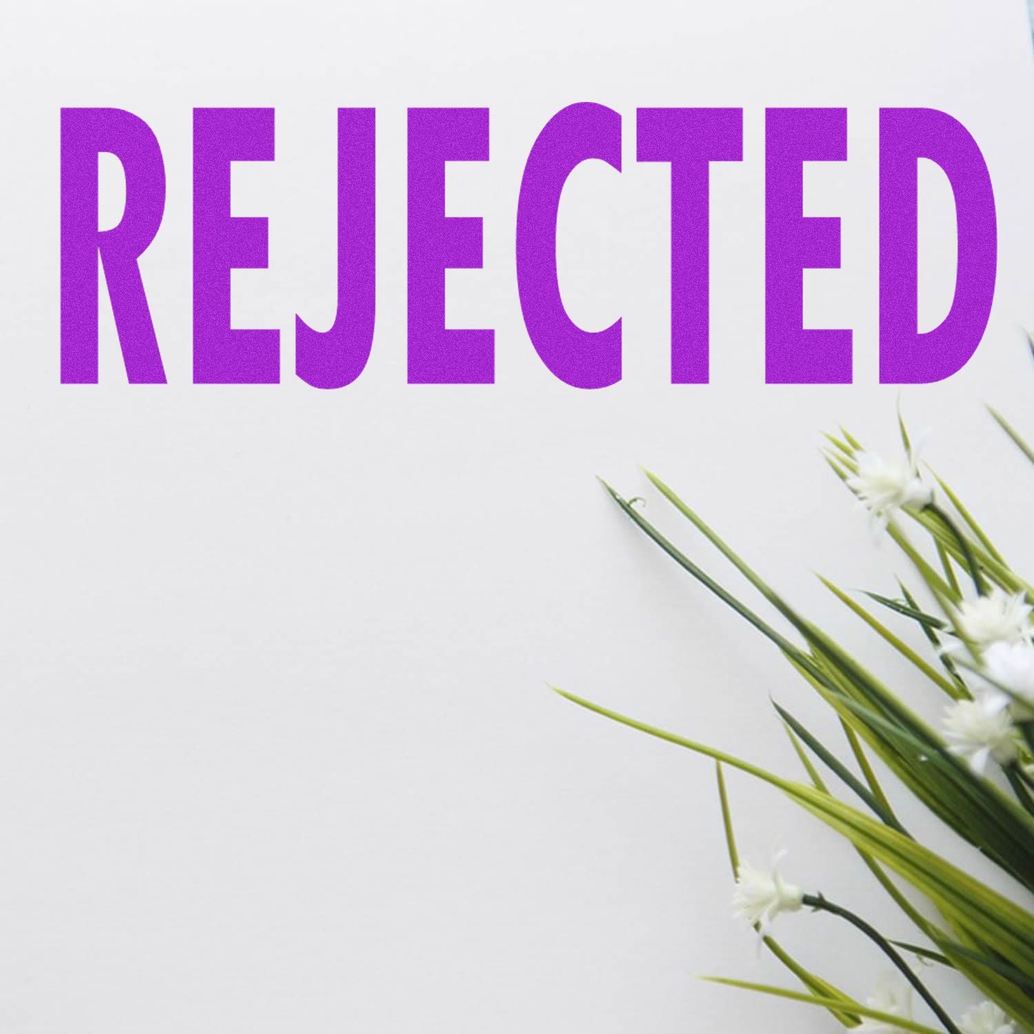 Rejected rubber stamp in bold purple letters on white paper with green plant in the corner.