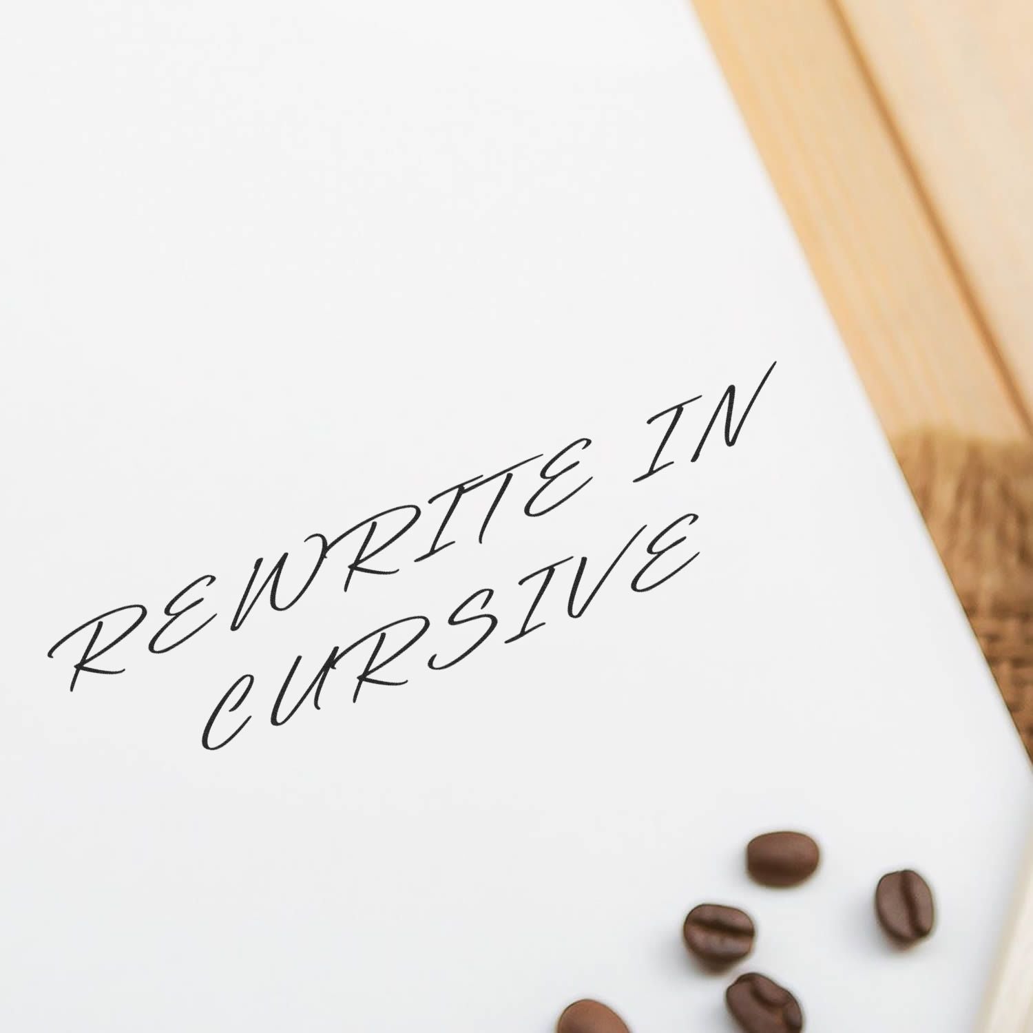 Self Inking Rewrite In Cursive Stamp imprint on white paper with coffee beans nearby on a wooden surface.