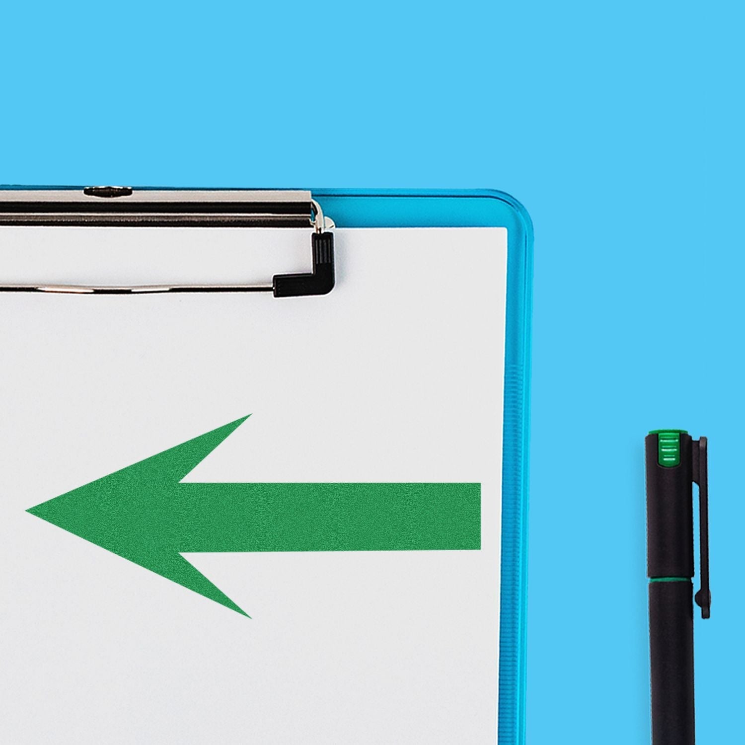 Self Inking Round Arrow Stamp in use, showing a green arrow stamped on a white paper clipped to a blue clipboard, with a pen beside it.