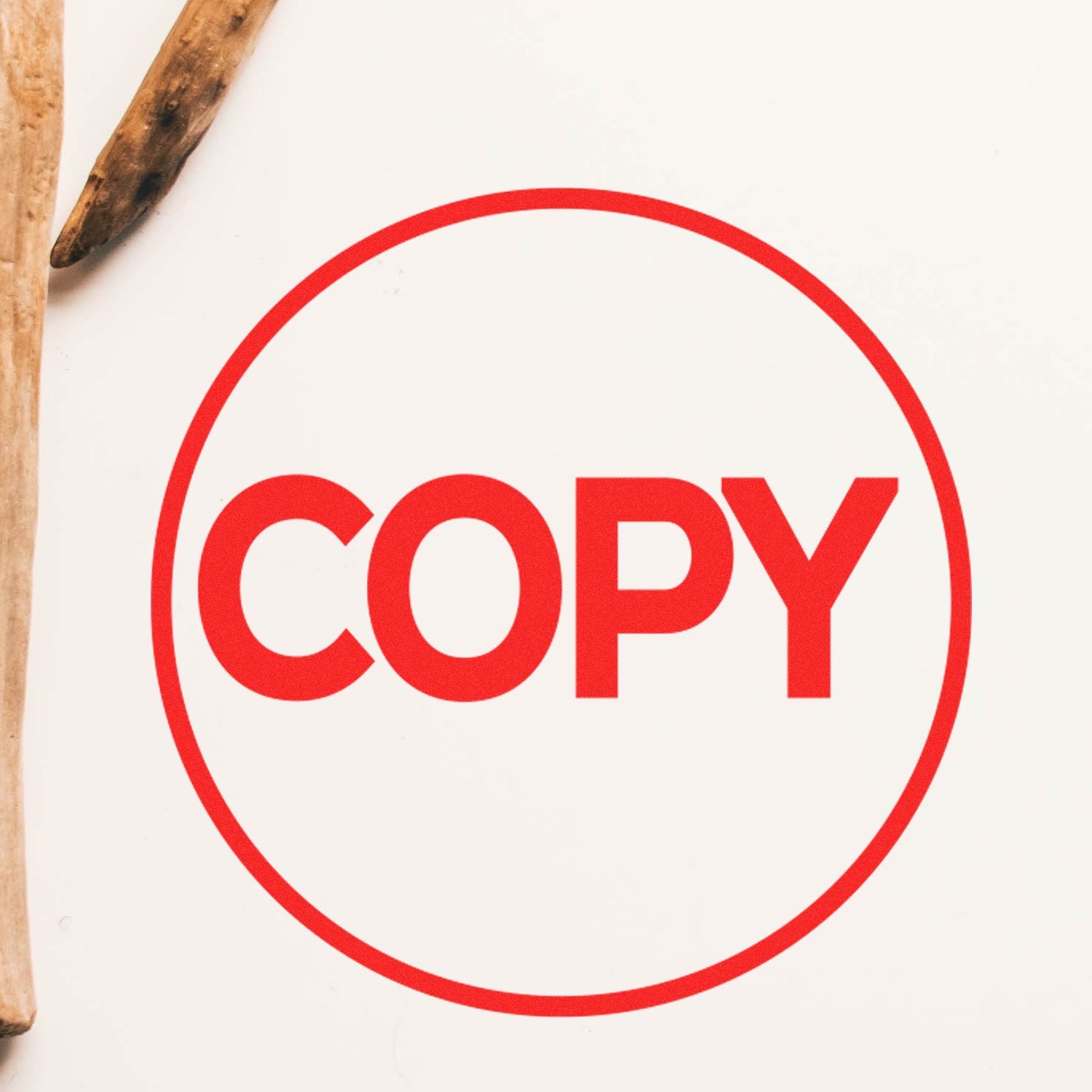 Round Copy Rubber Stamp with bold red 'COPY' text inside a red circle on a white background, wooden sticks nearby.