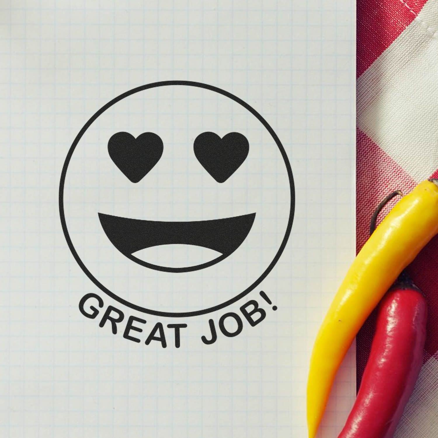 Round Great Job Smiley Rubber Stamp on graph paper with heart eyes and a wide smile, next to red and yellow chili peppers.