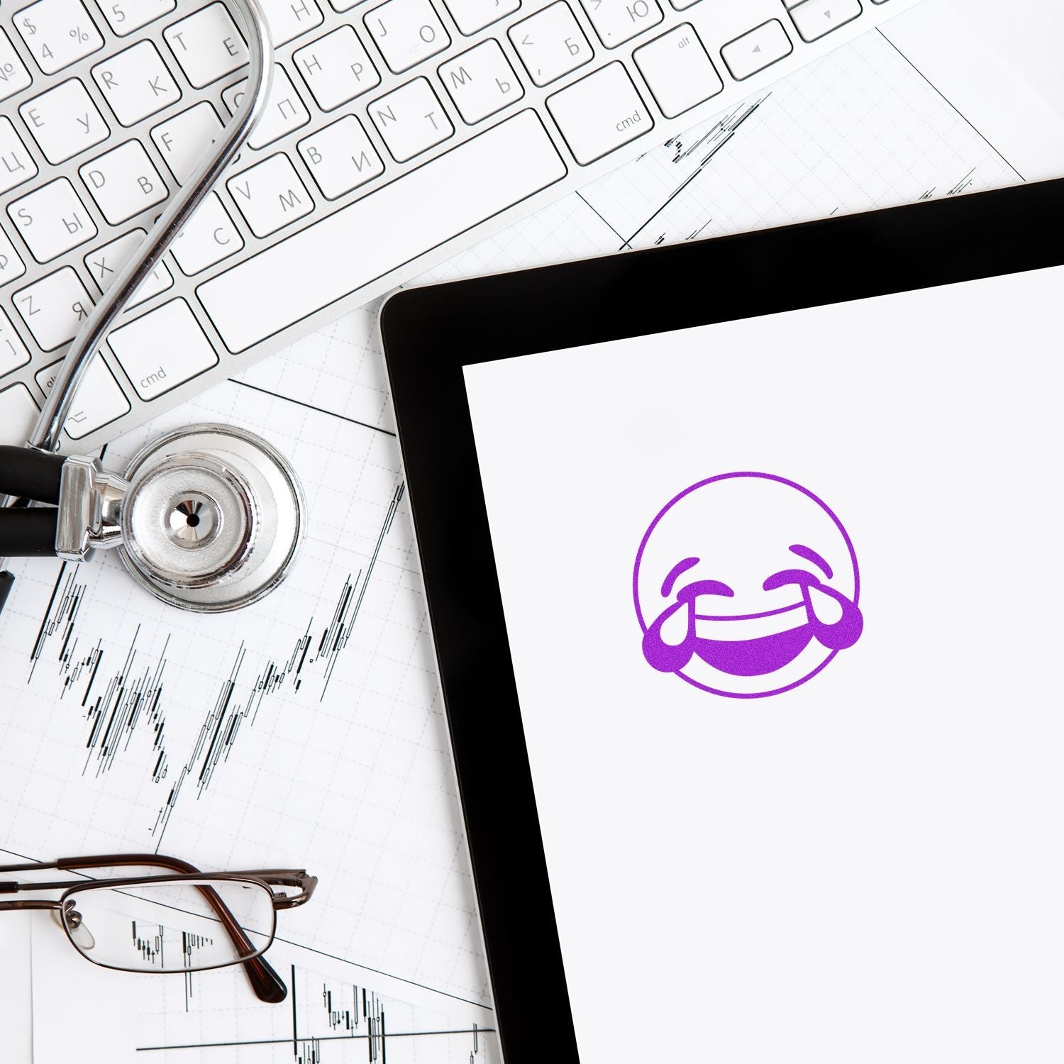 Self Inking Round Laughing Smiley Stamp in purple ink on paper, surrounded by a stethoscope, keyboard, and glasses.