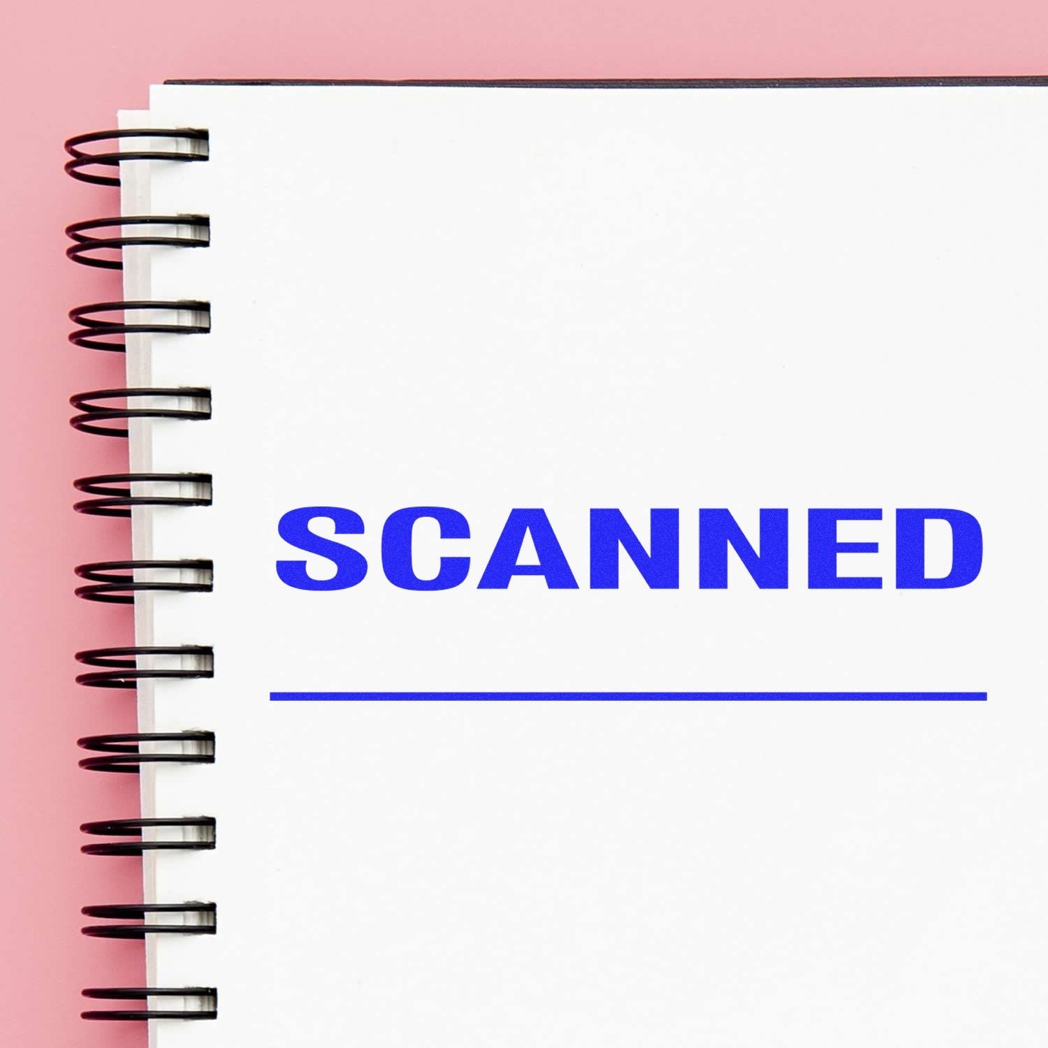 Self Inking Scanned with Line Stamp in blue ink on a white spiral notebook, against a pink background.