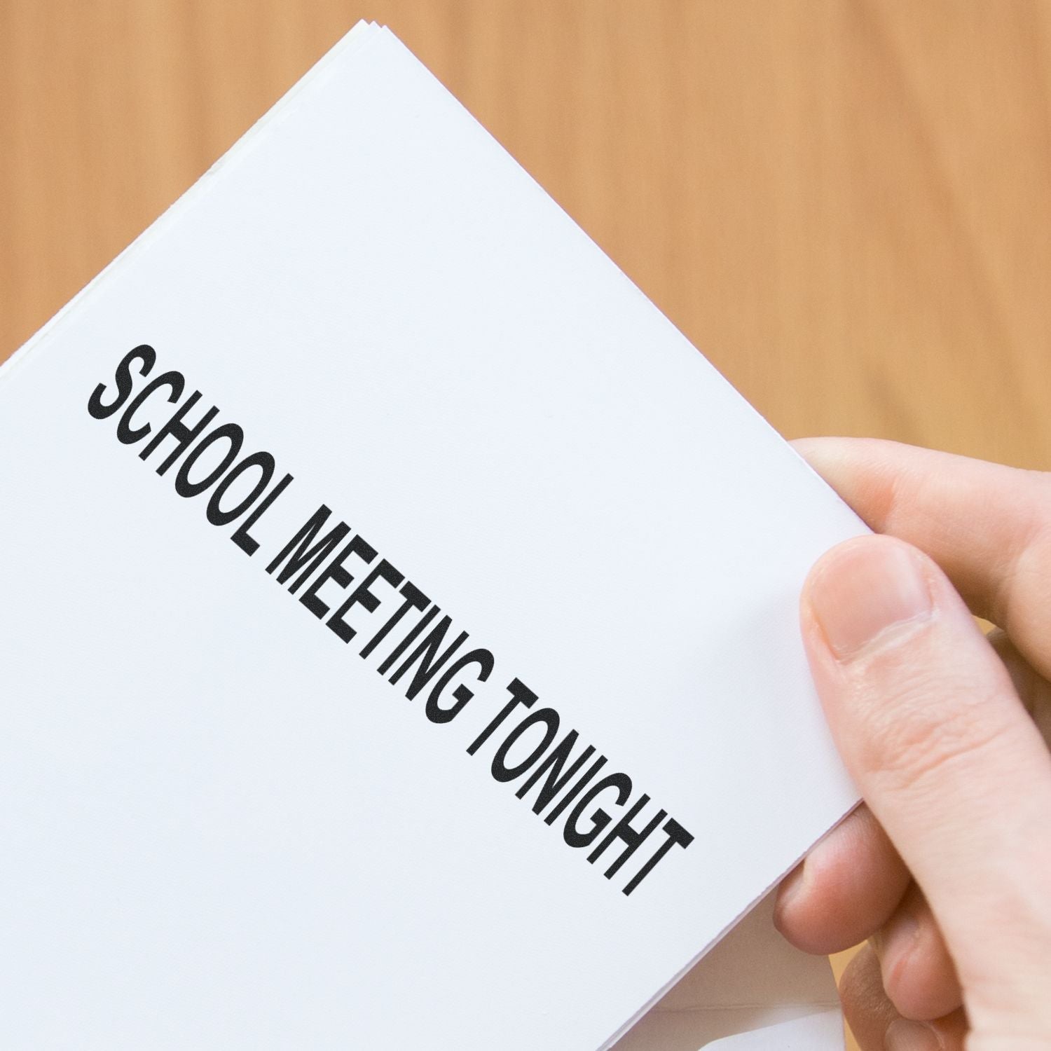 Hand holding a paper stamped with SCHOOL MEETING TONIGHT using the Self Inking School Meeting Tonight Stamp.