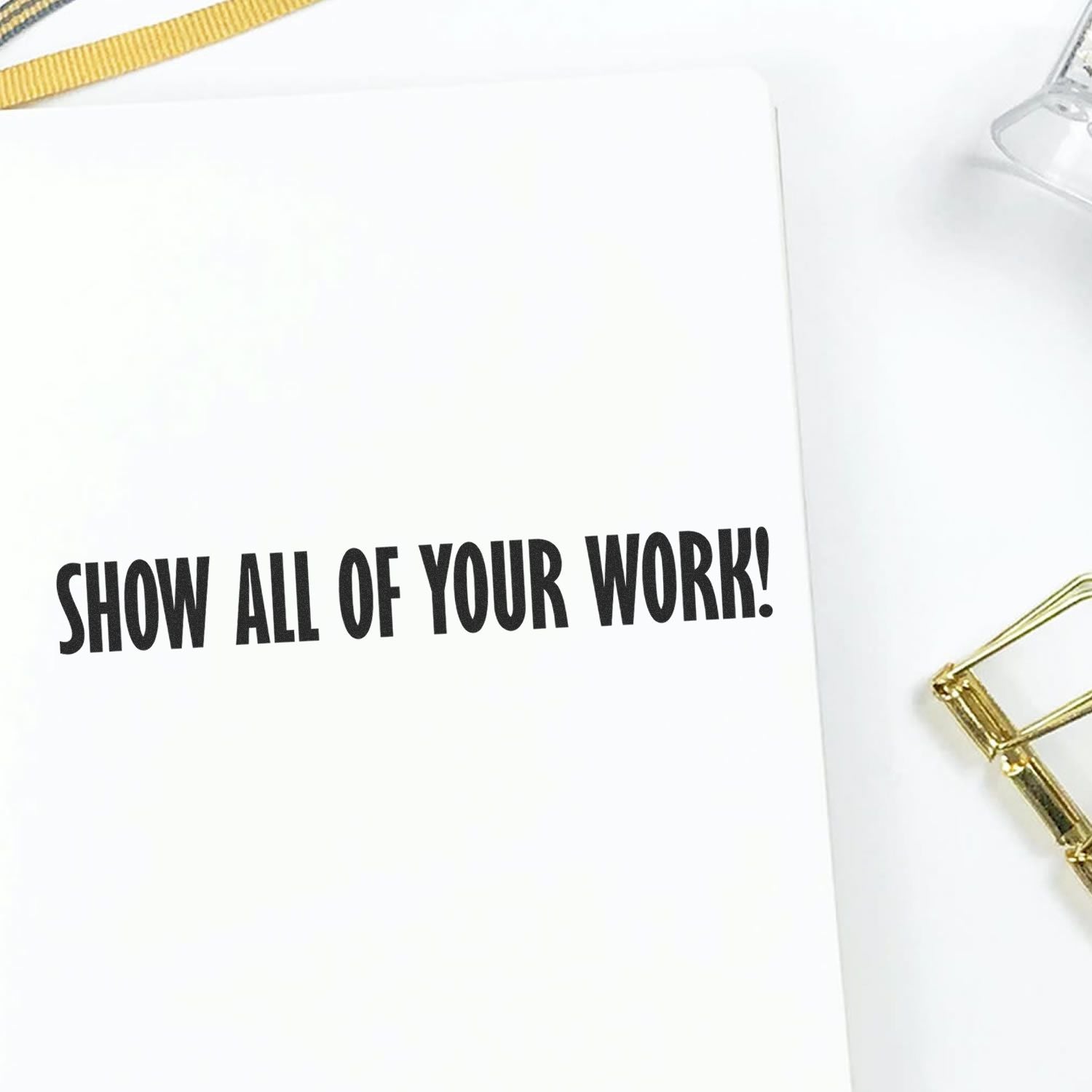 Show All Of Your Work rubber stamp impression on a white paper, with a gold paper clip and a clear stamp holder nearby.